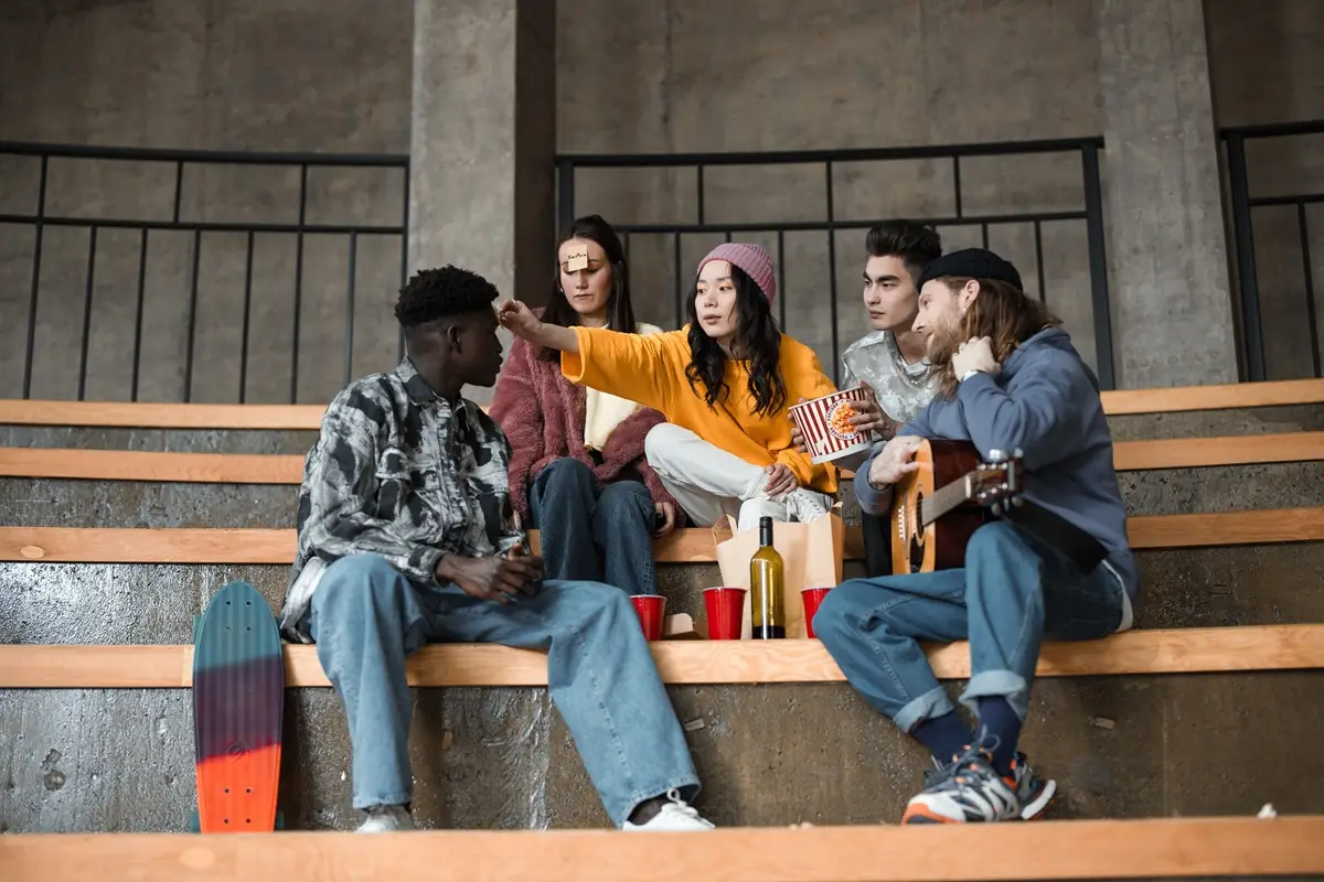 Group of friends enjoying time together indoors with snacks and music.