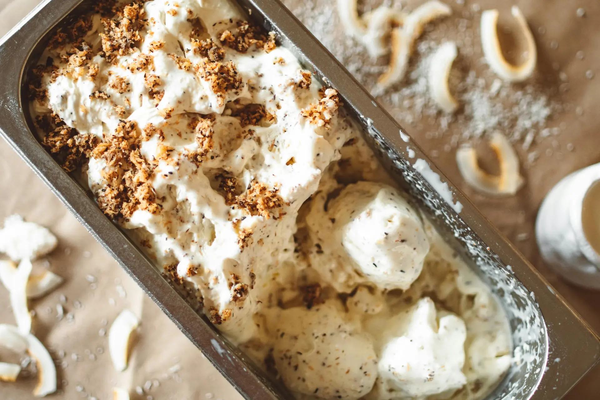 Vanilla Ice cream in tin with chocolate shavings on top.