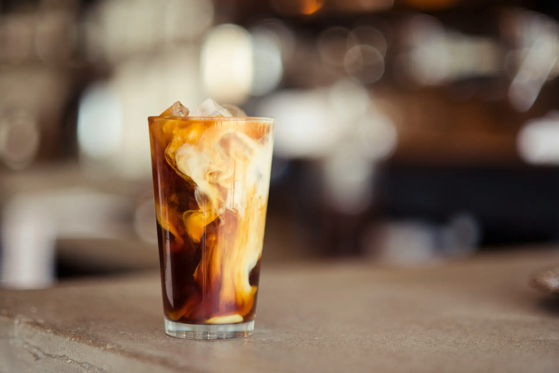 A glass cup filled with ice latte on tabletop