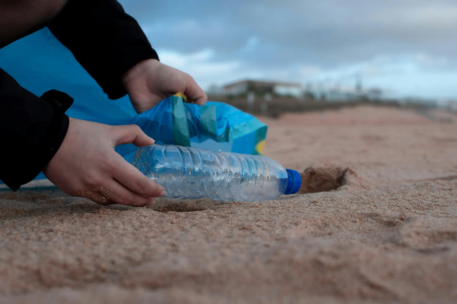 Person putting empty plastic bottle in bag