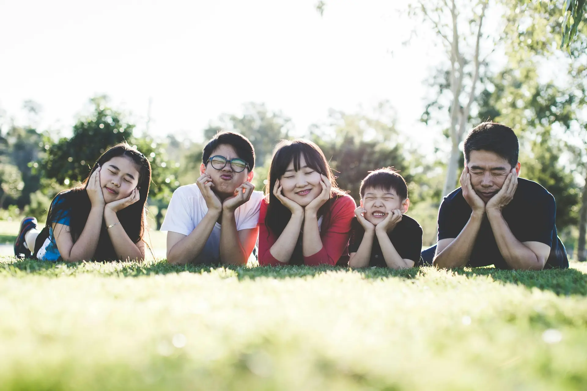 A family of five posing on the grass
