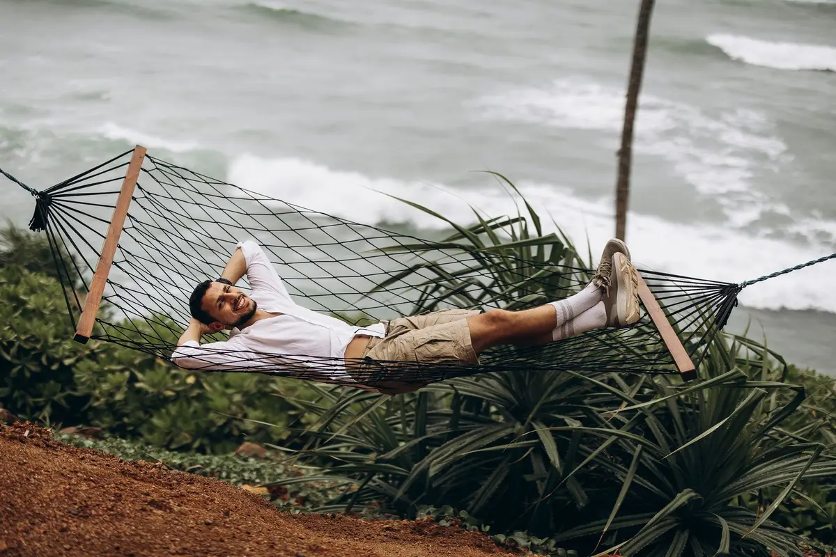 Man enjoying a serene moment in a hammock by the ocean.