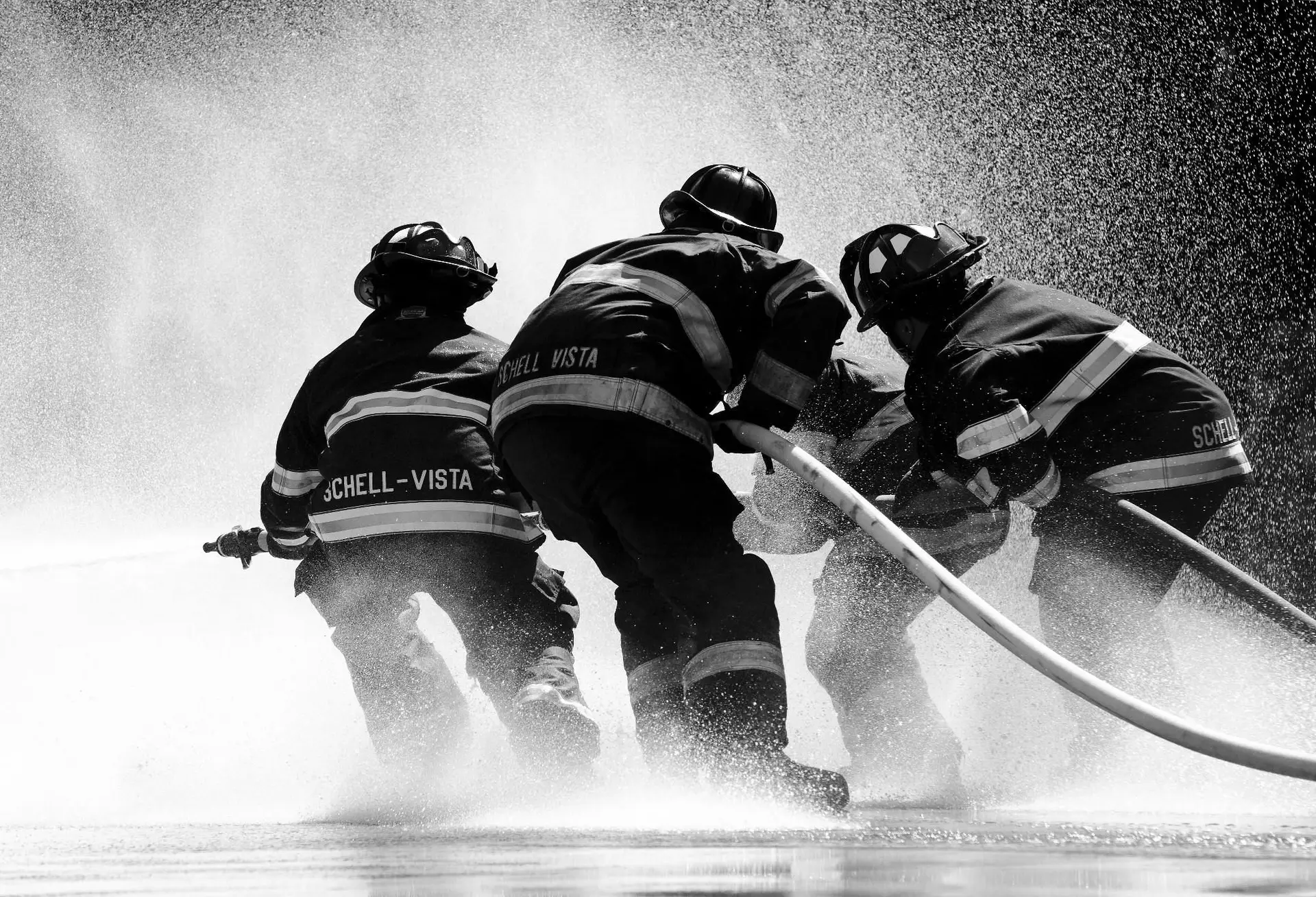 Three firemen putting out a fire.