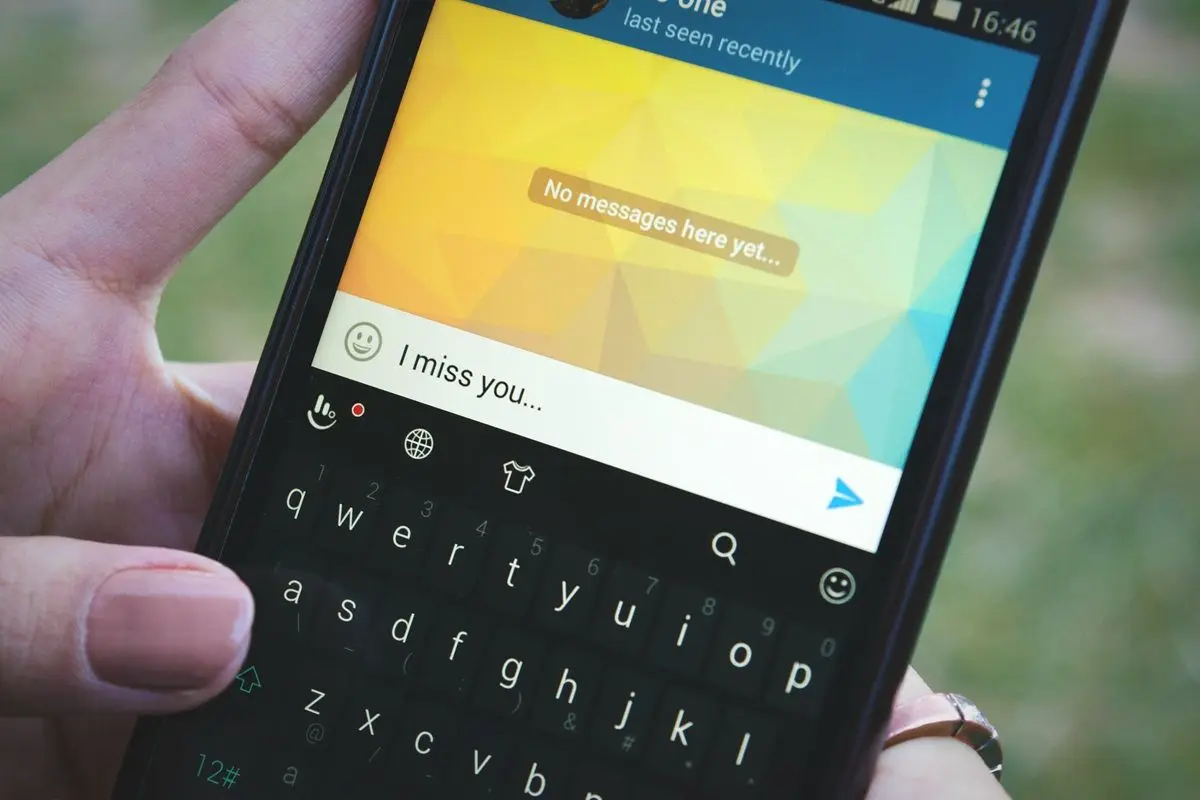 A person sending a I miss you text from a back phone.