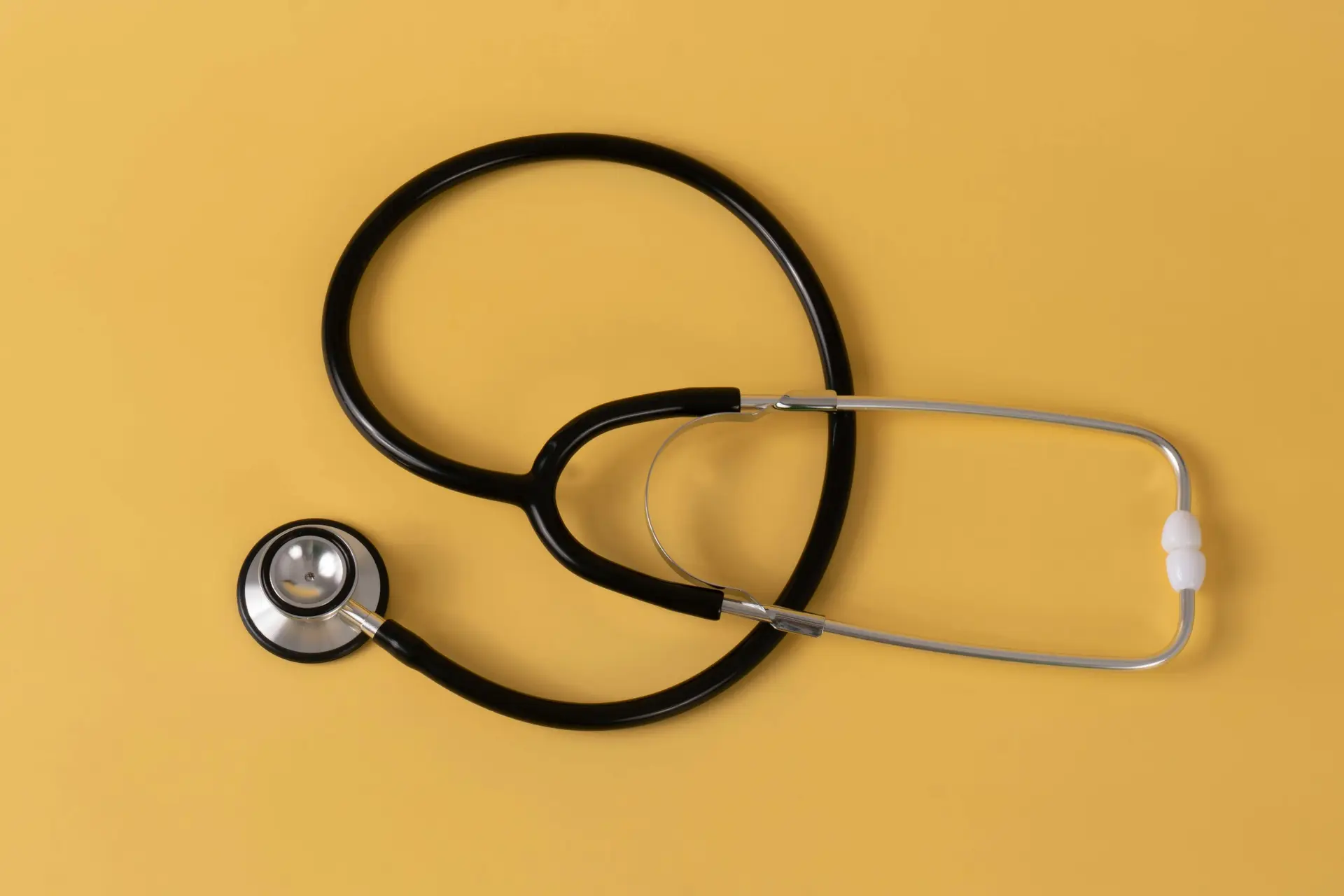 A Stethoscope kept on a yellow background.