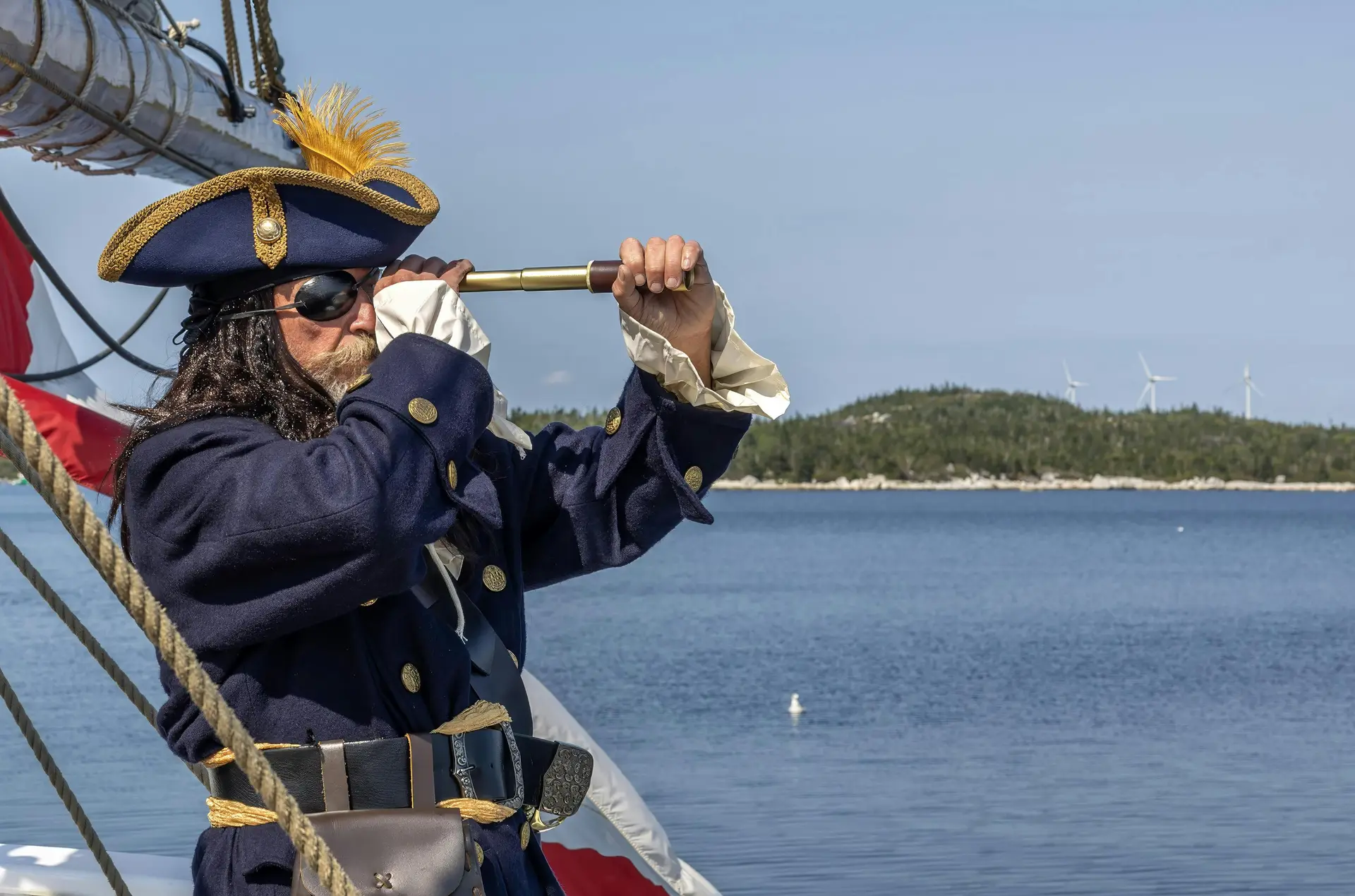 A person wearing pirate costume and looking through the spyglass.