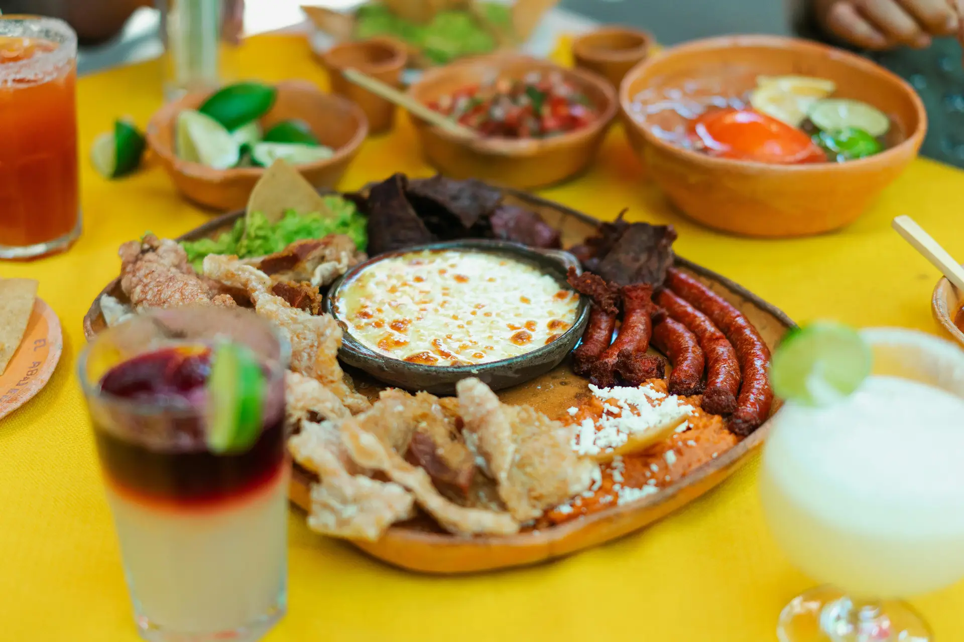 Bunch of mexican food on a yellow table.
