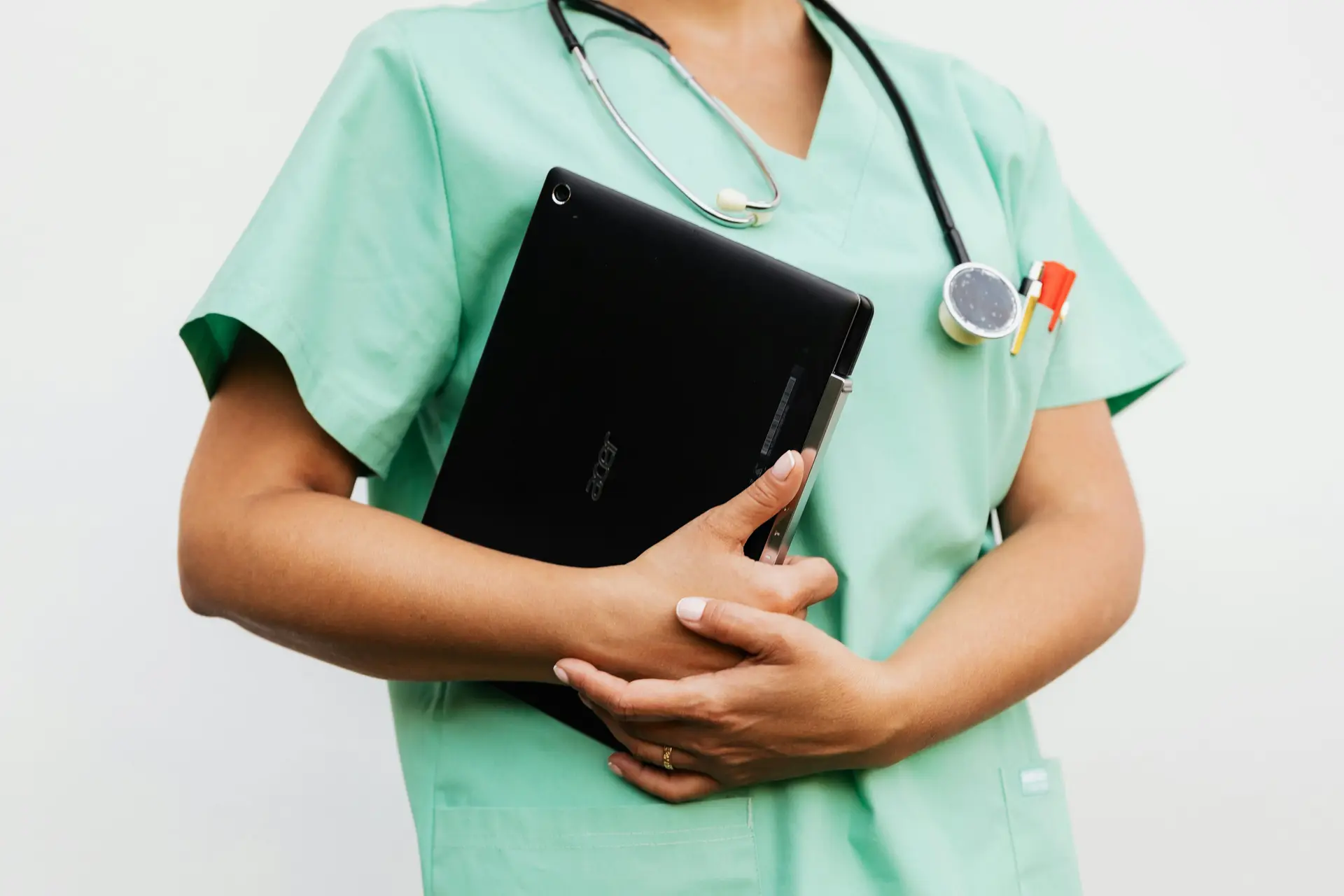 Nurse holding a tablet and has a stethoscope as well.