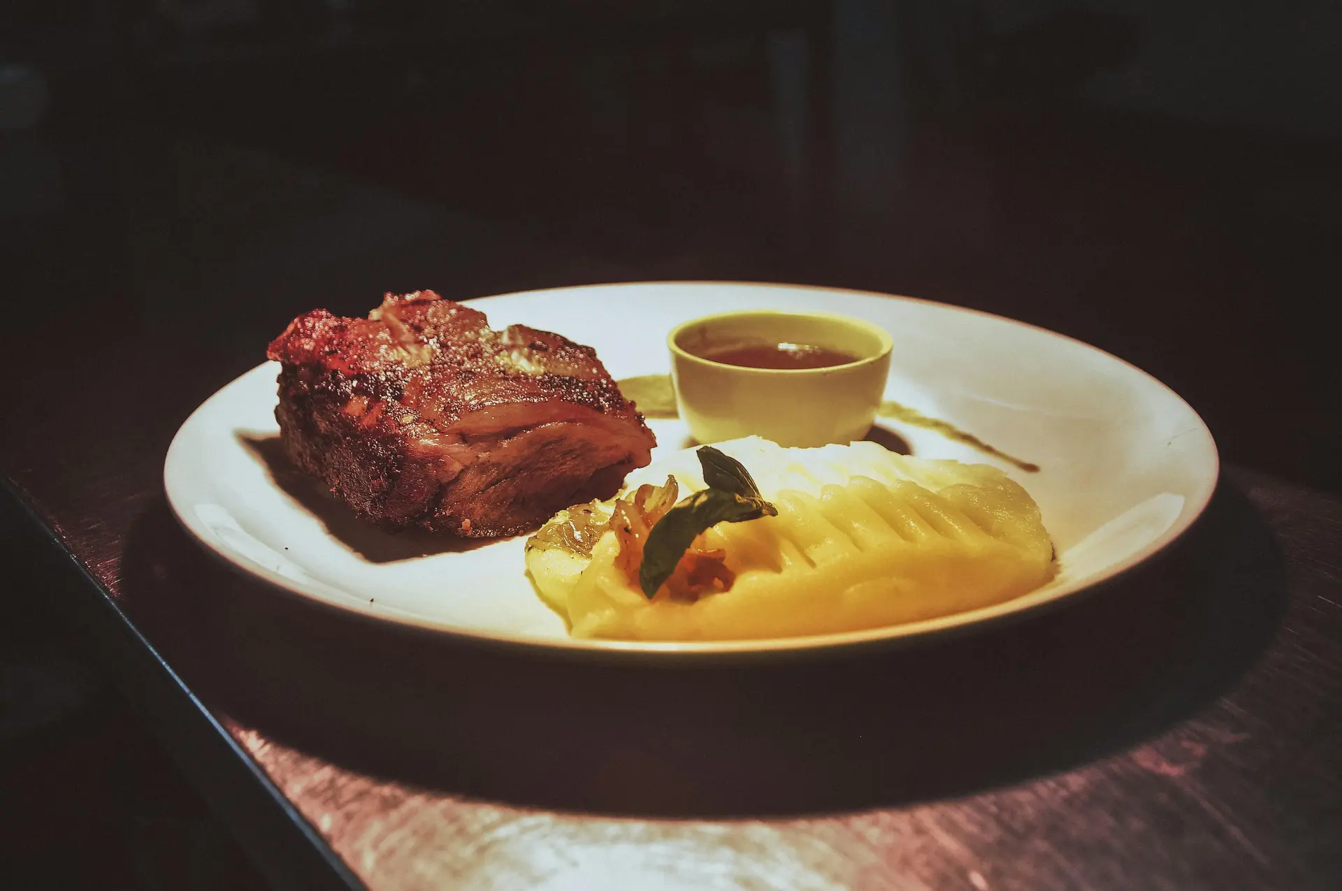 Steak served with creamy mashed potato and gravy on the side