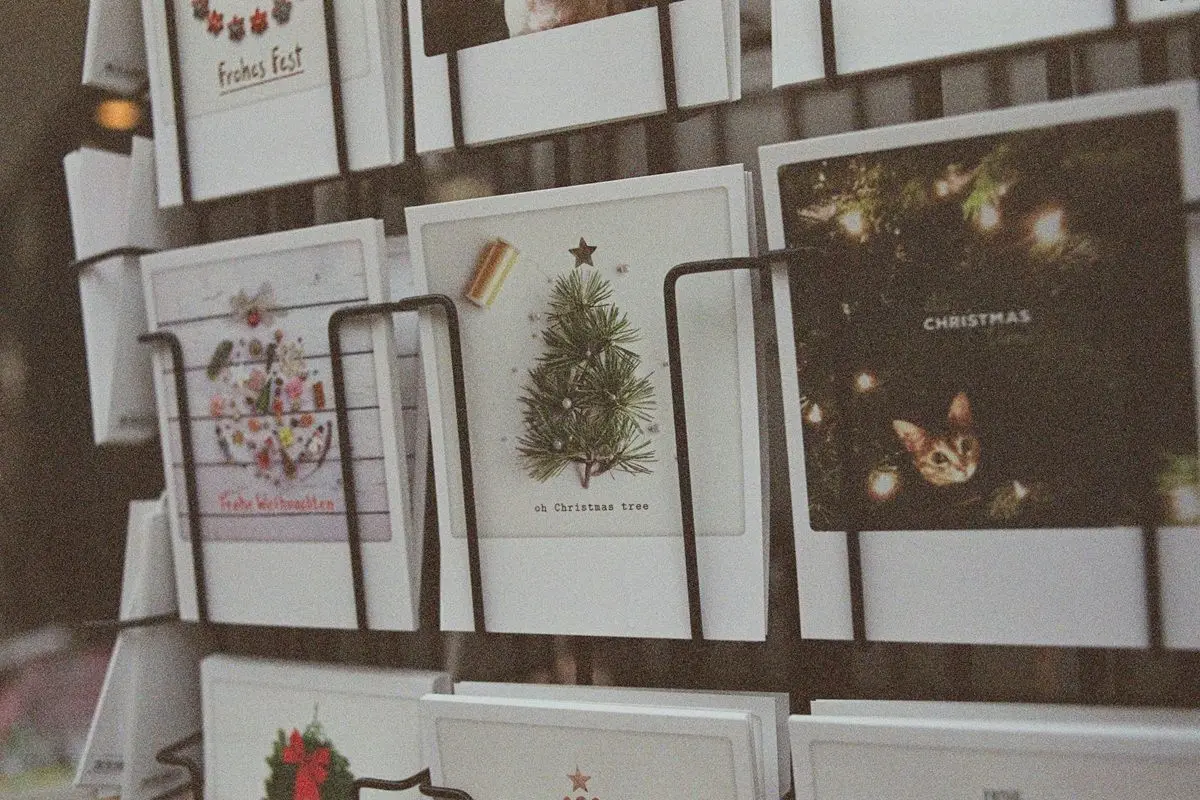 Various styles of christmas cards are on display in a shop.