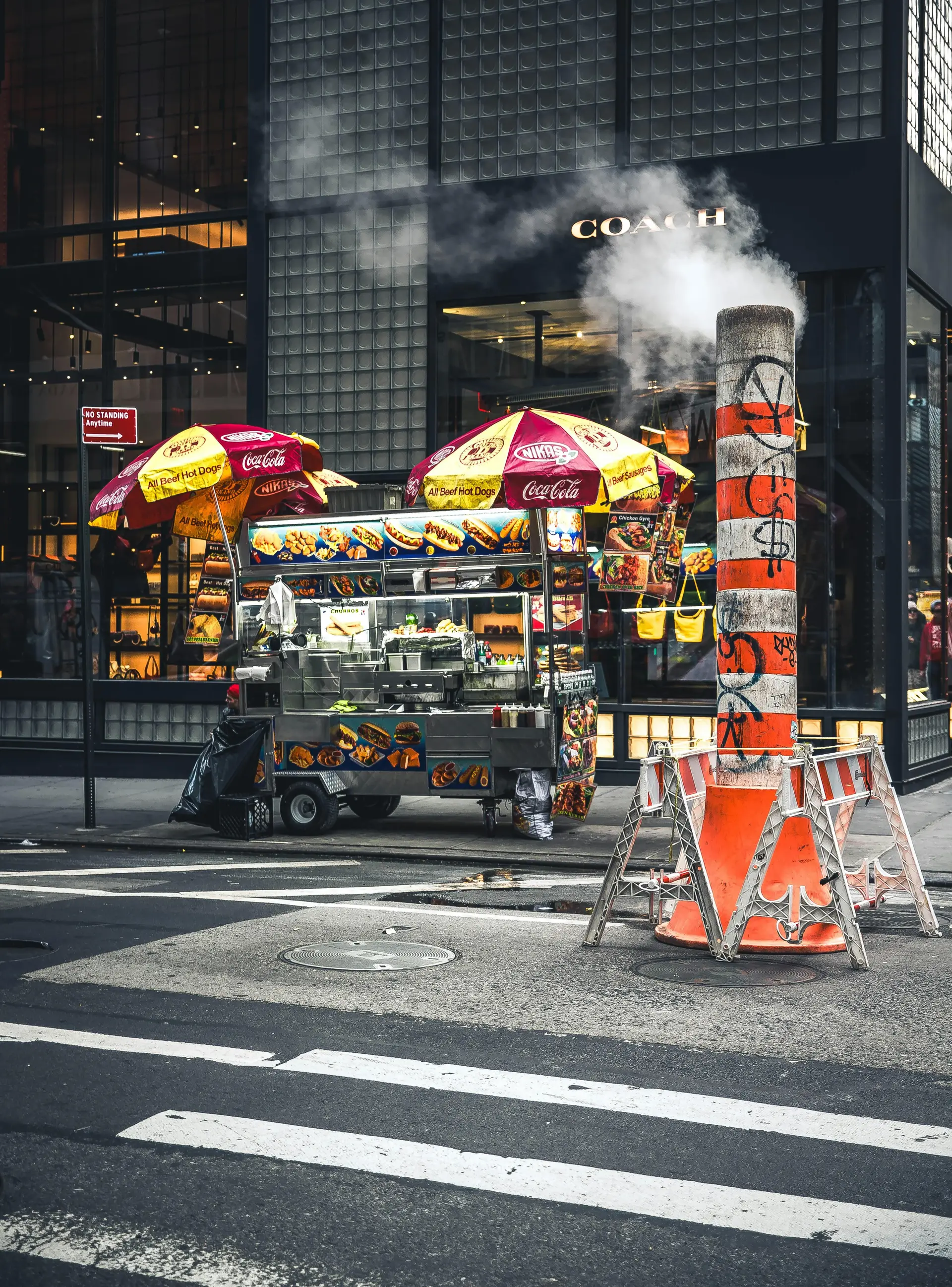 Hot dog stand on corner of a street.