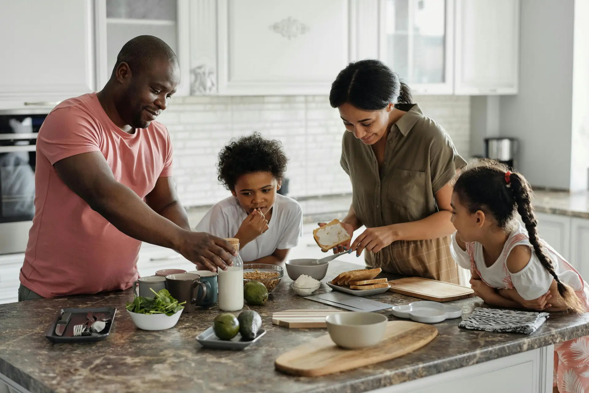 Family of four cooking together in the kitchen