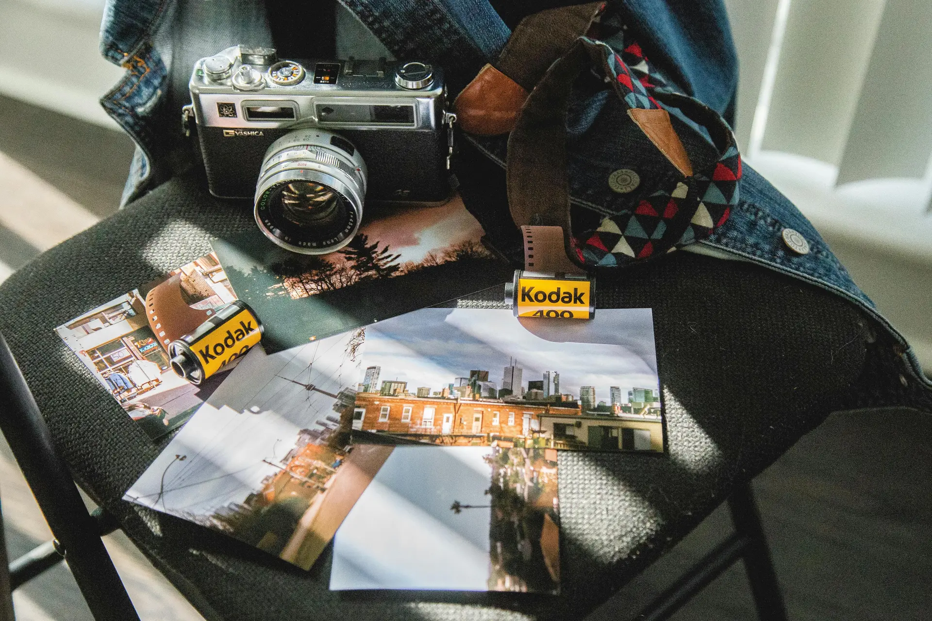 A kodak 400 camea on a table along with a jacket.