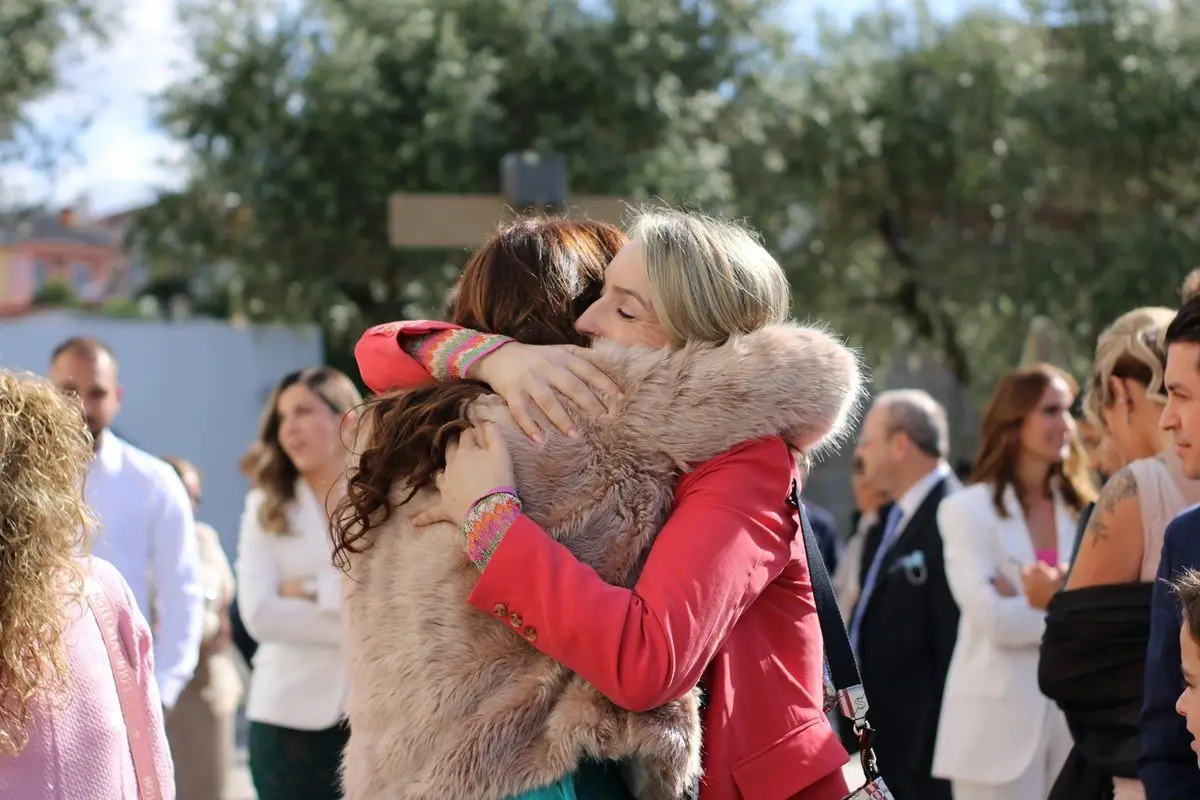 Two person hugging in a crowded street.