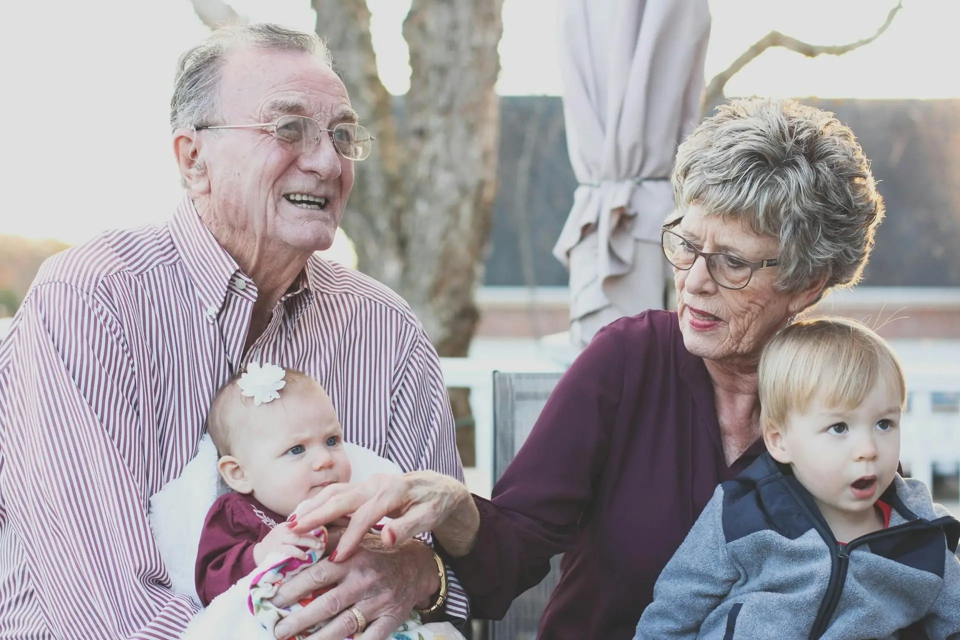 Grand parents sitting with their grand kids on their lap