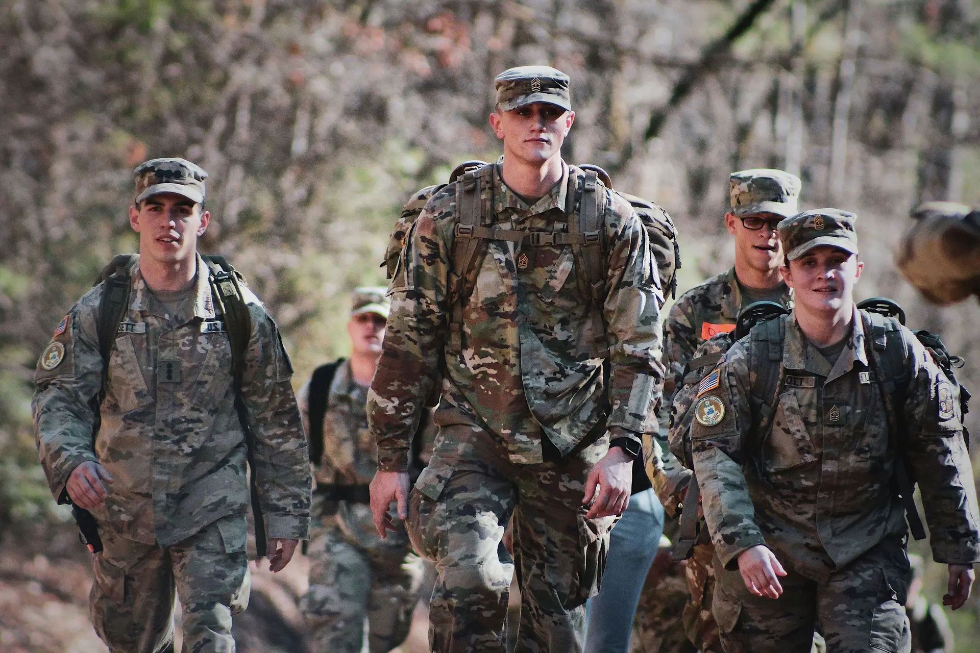 Men in camouflage uniform standing on field during daytime.