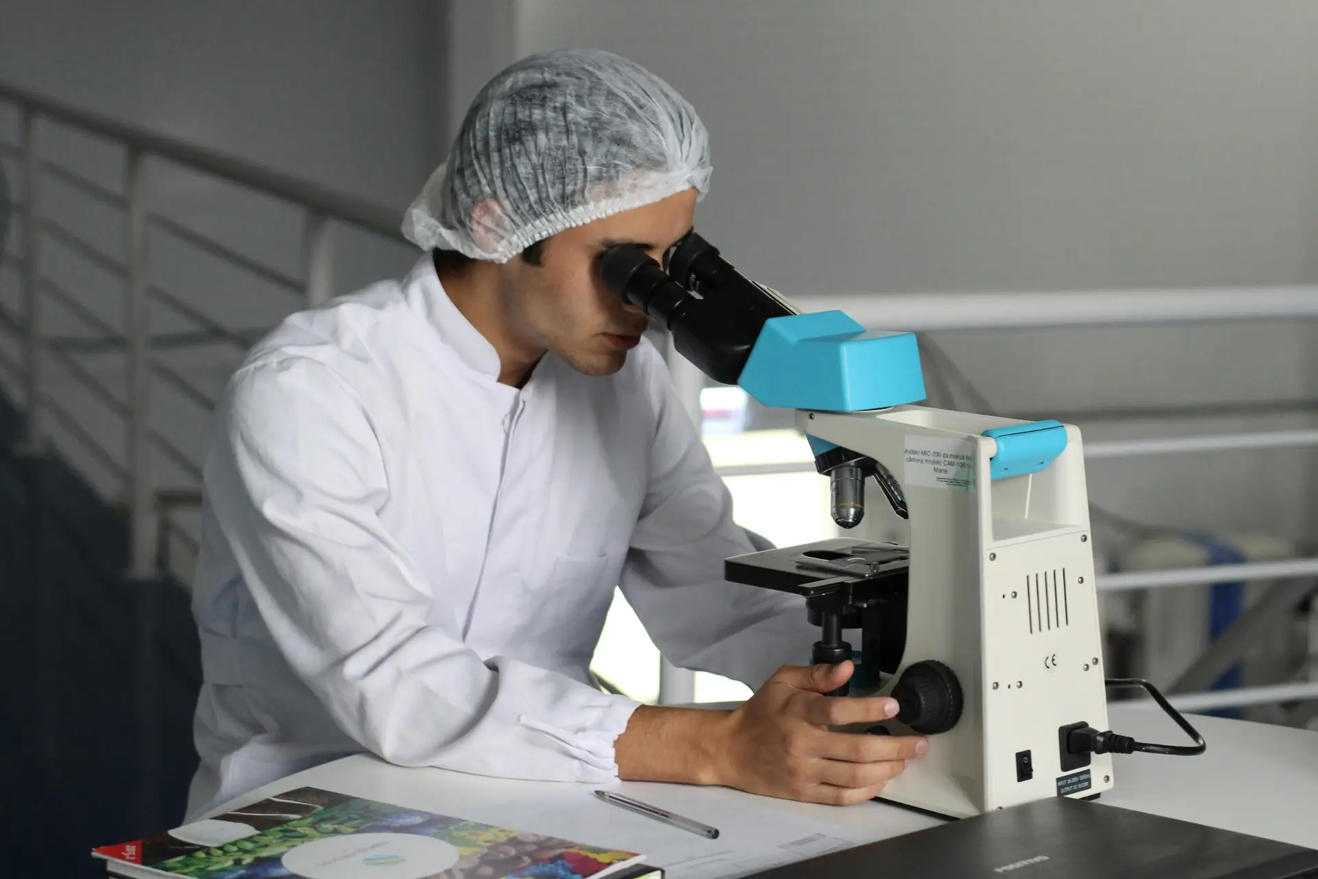 A scientist looking through microscope.