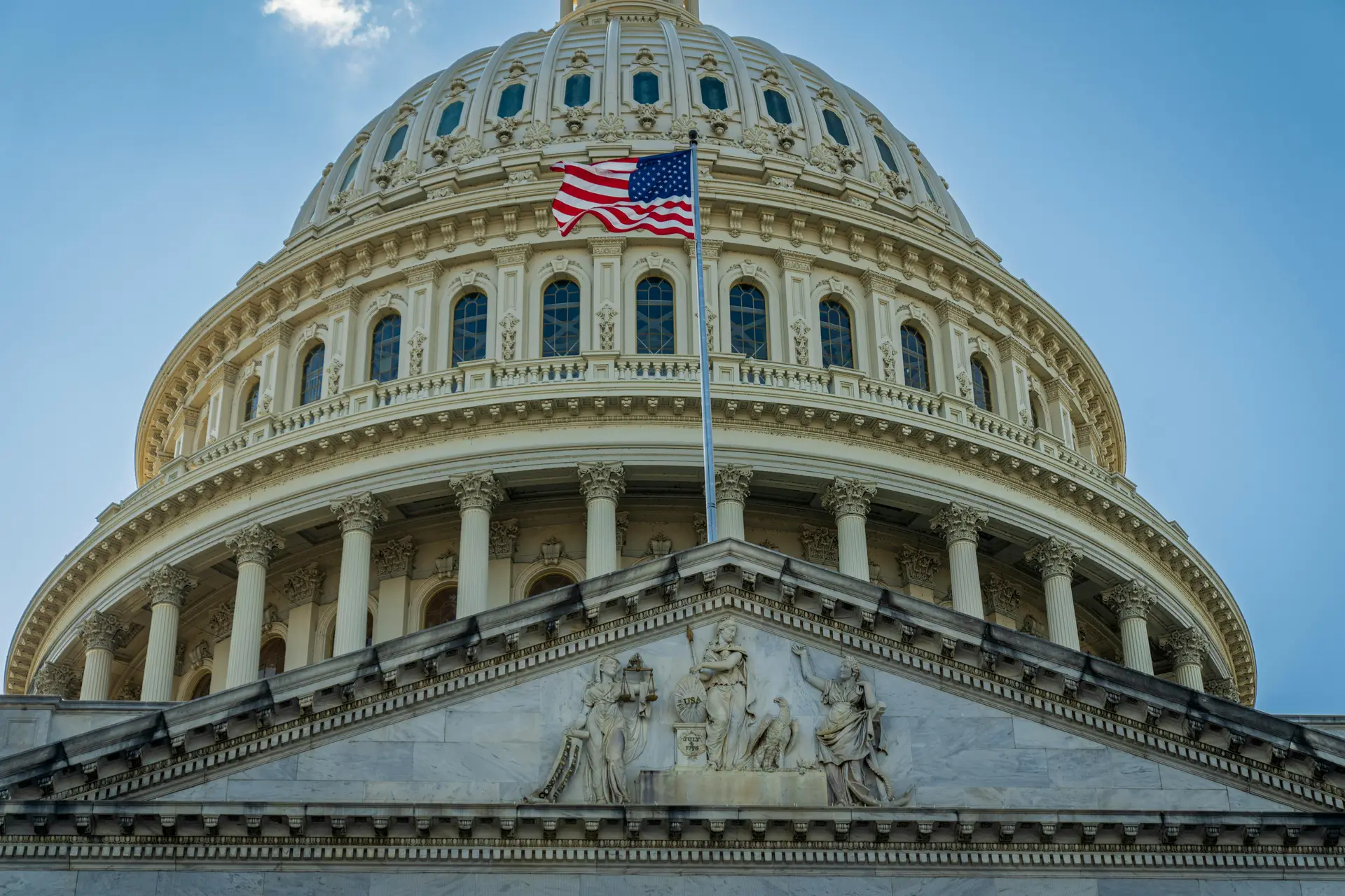 The US Capitol buillding with the american flag raised in front of it.