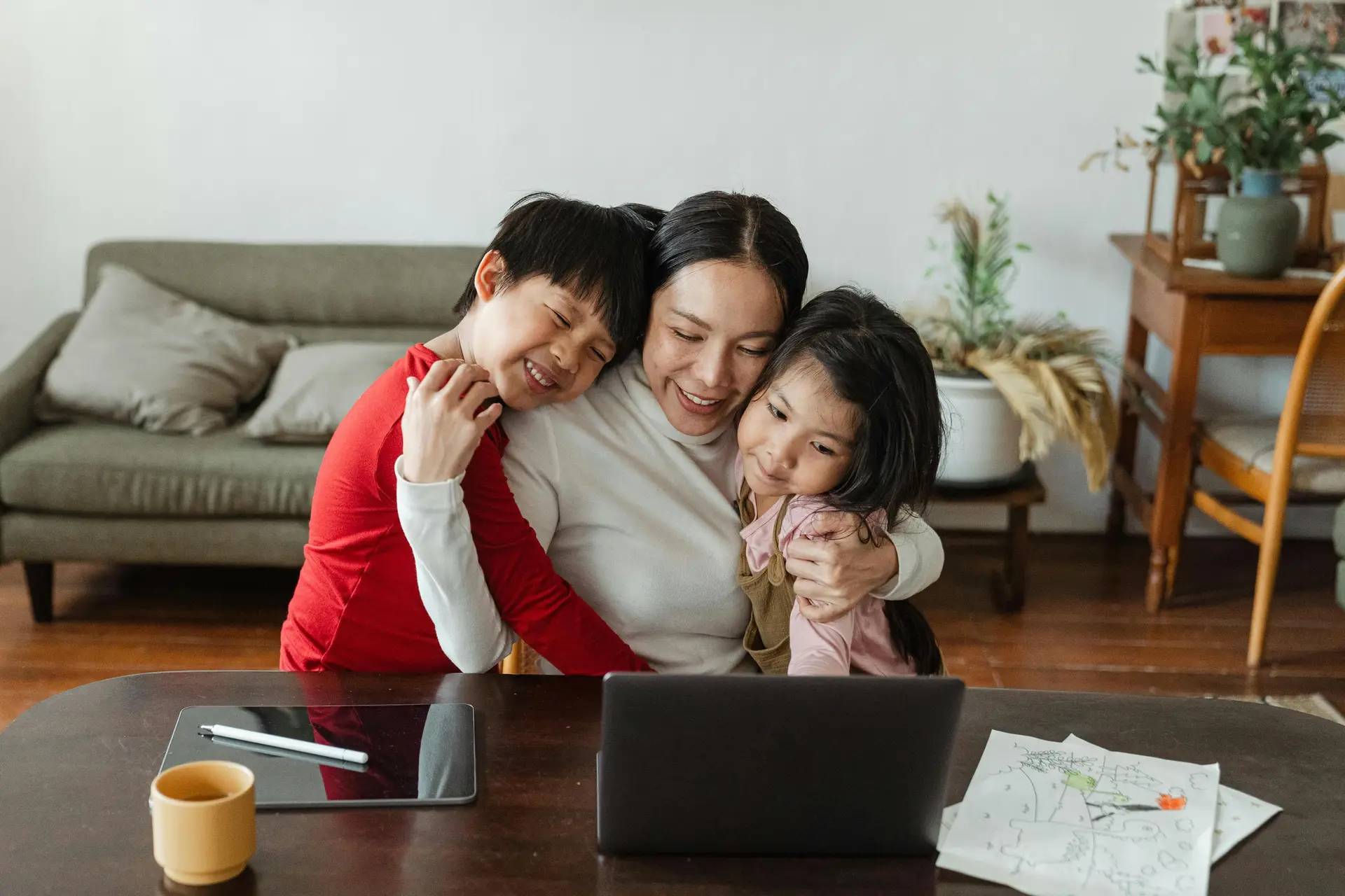 A mother hugging her son and daughter.