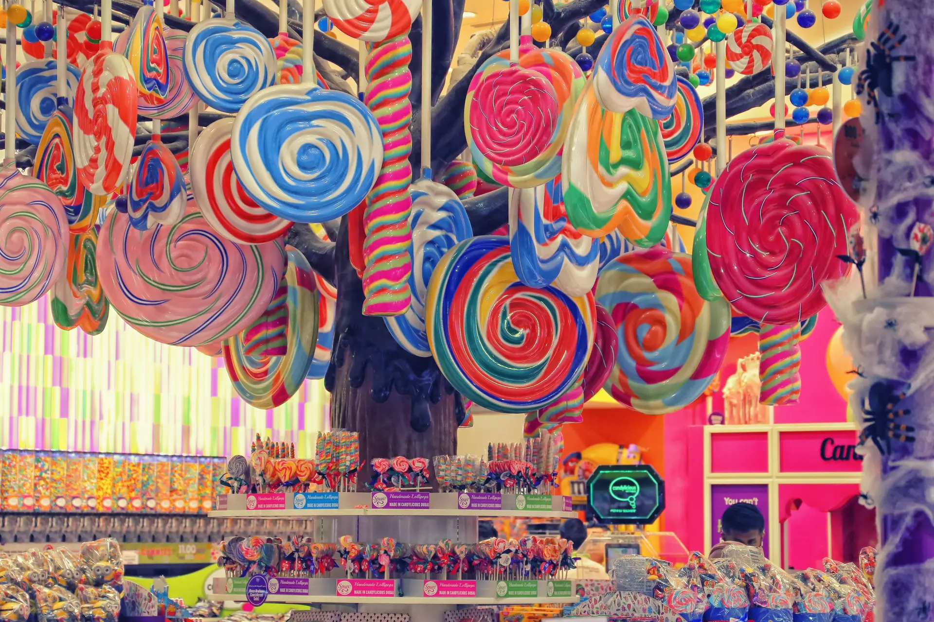 Multicolored lollipops hanging upside down in a candy shop.