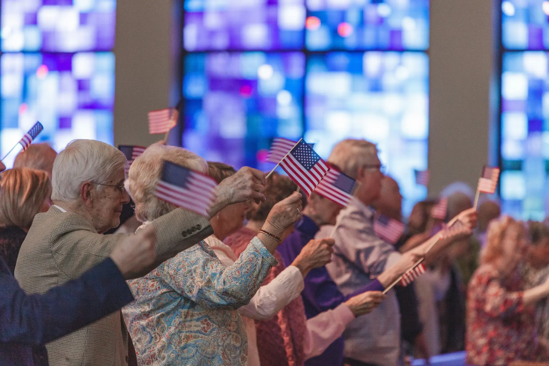 Old veterans waving small american flags.