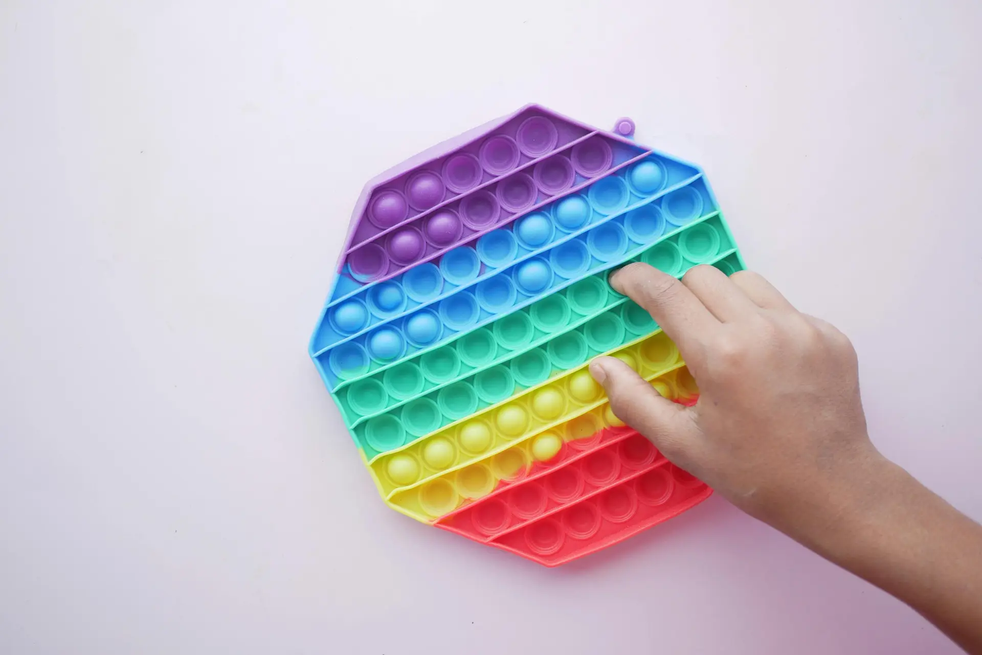 Person Playing with a Blue Yellow and Red Plastic ASMR Toy.
