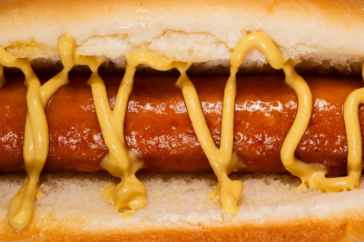 Delicious hotdog with mustard in a soft bun, perfect for lunch or snack on National Mustard Day.