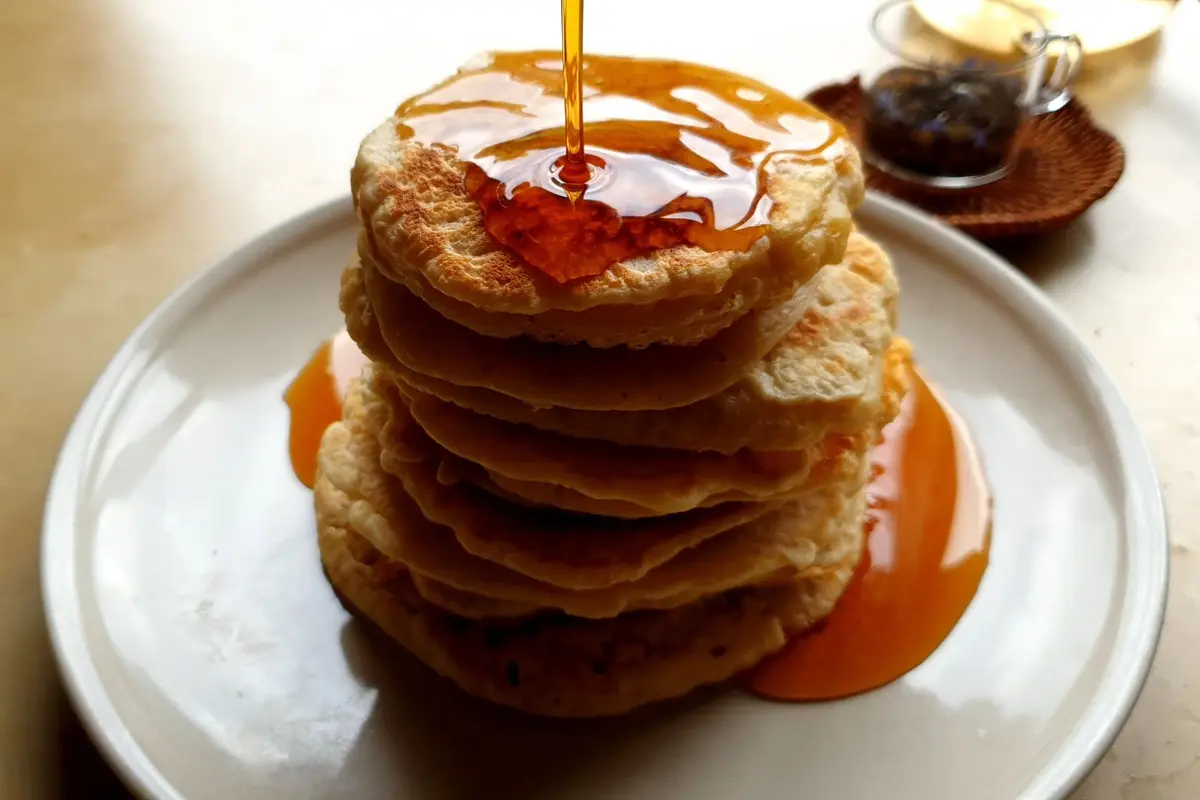Delicious pancakes stacked high, drenched in syrup, perfect for breakfast lovers on National Pancake Day.