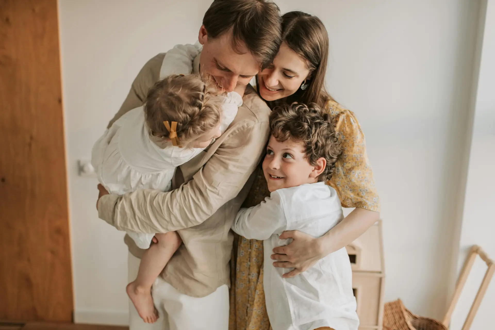 Parents and their two babies embracing each other in an affectionate way.