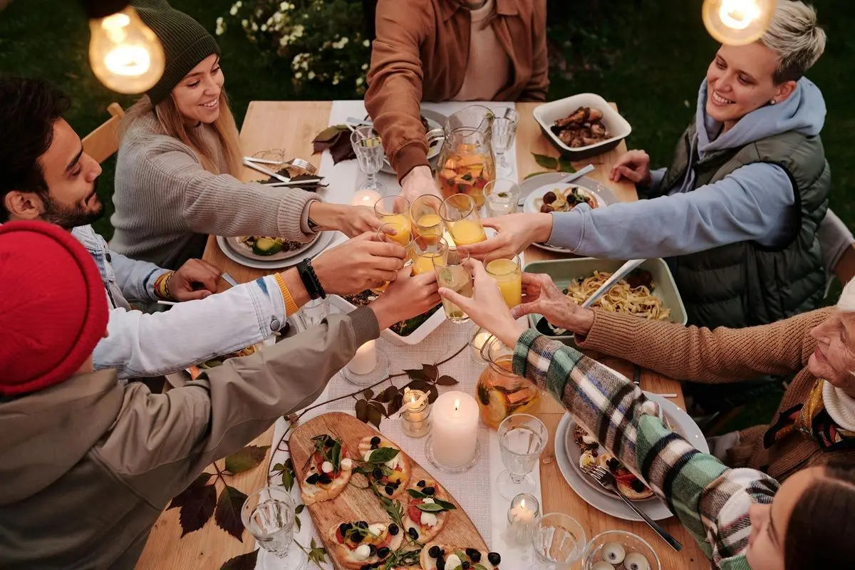 A bunch of people doing a Thanksgivings toast on a Thanksgivings dinner party.