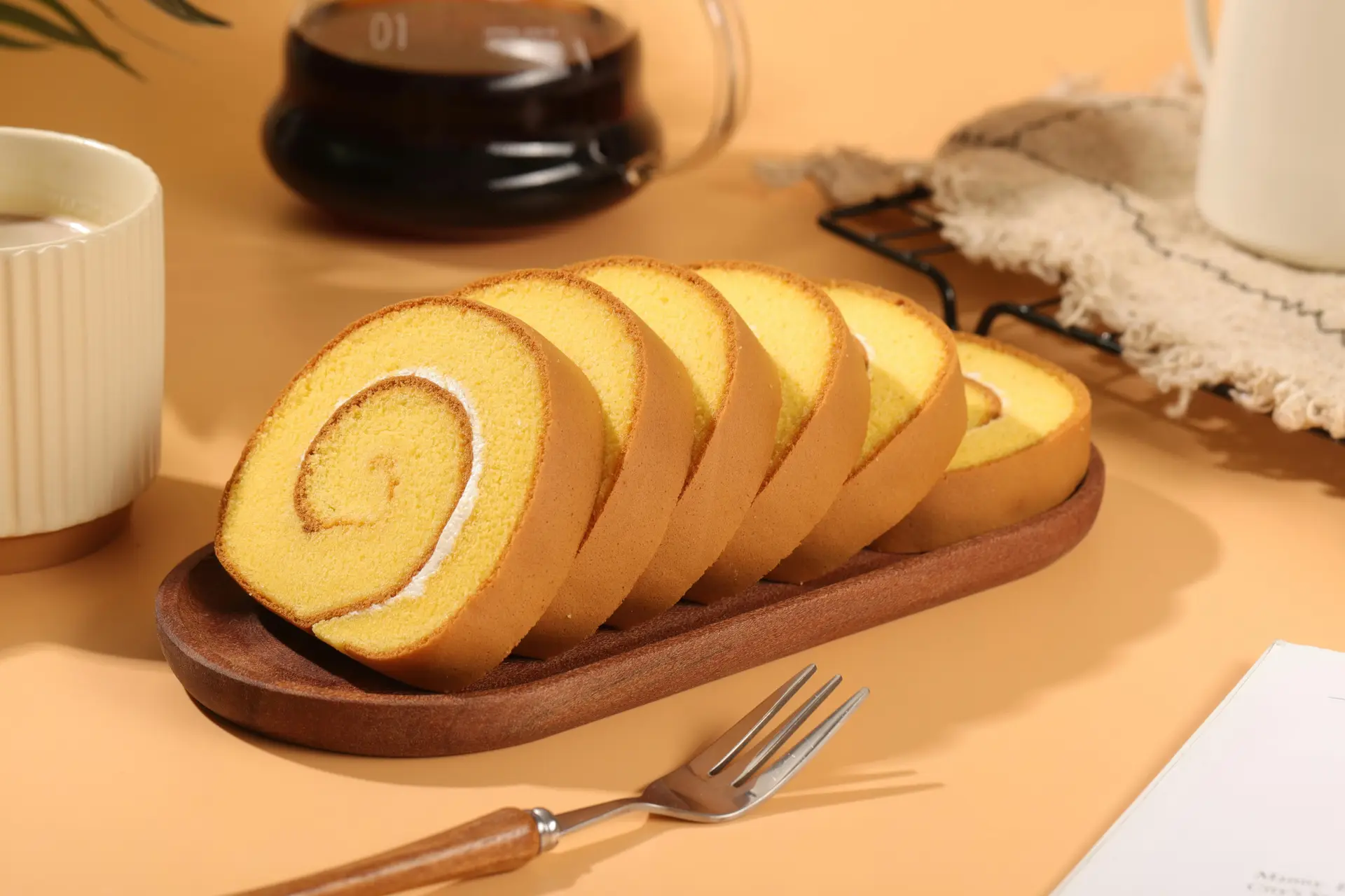 Rolled sponge cake served on a wooden dish.