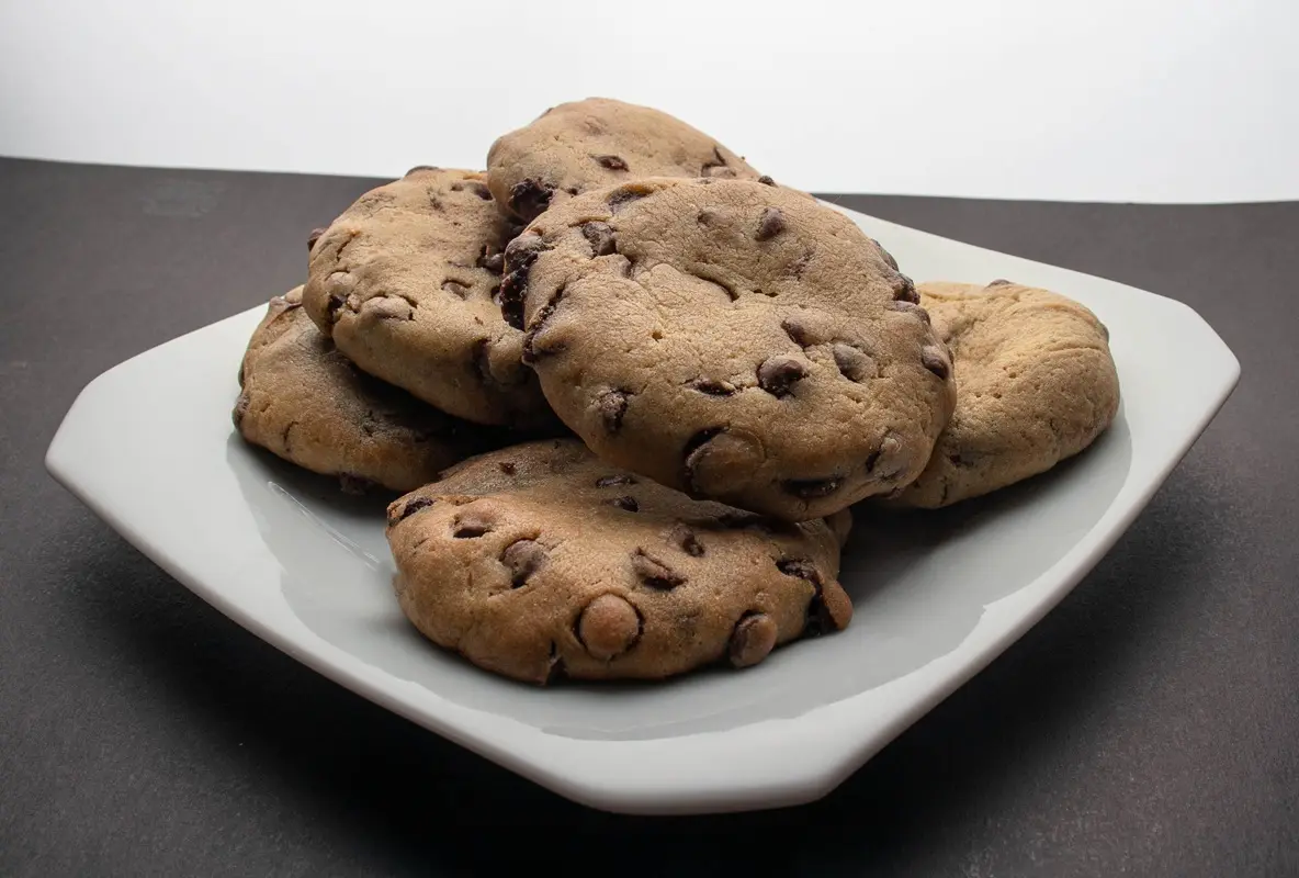 Freshly baked chocolate chip cookies on a plate, perfect for dessert on National Chocolate chip cookie day.