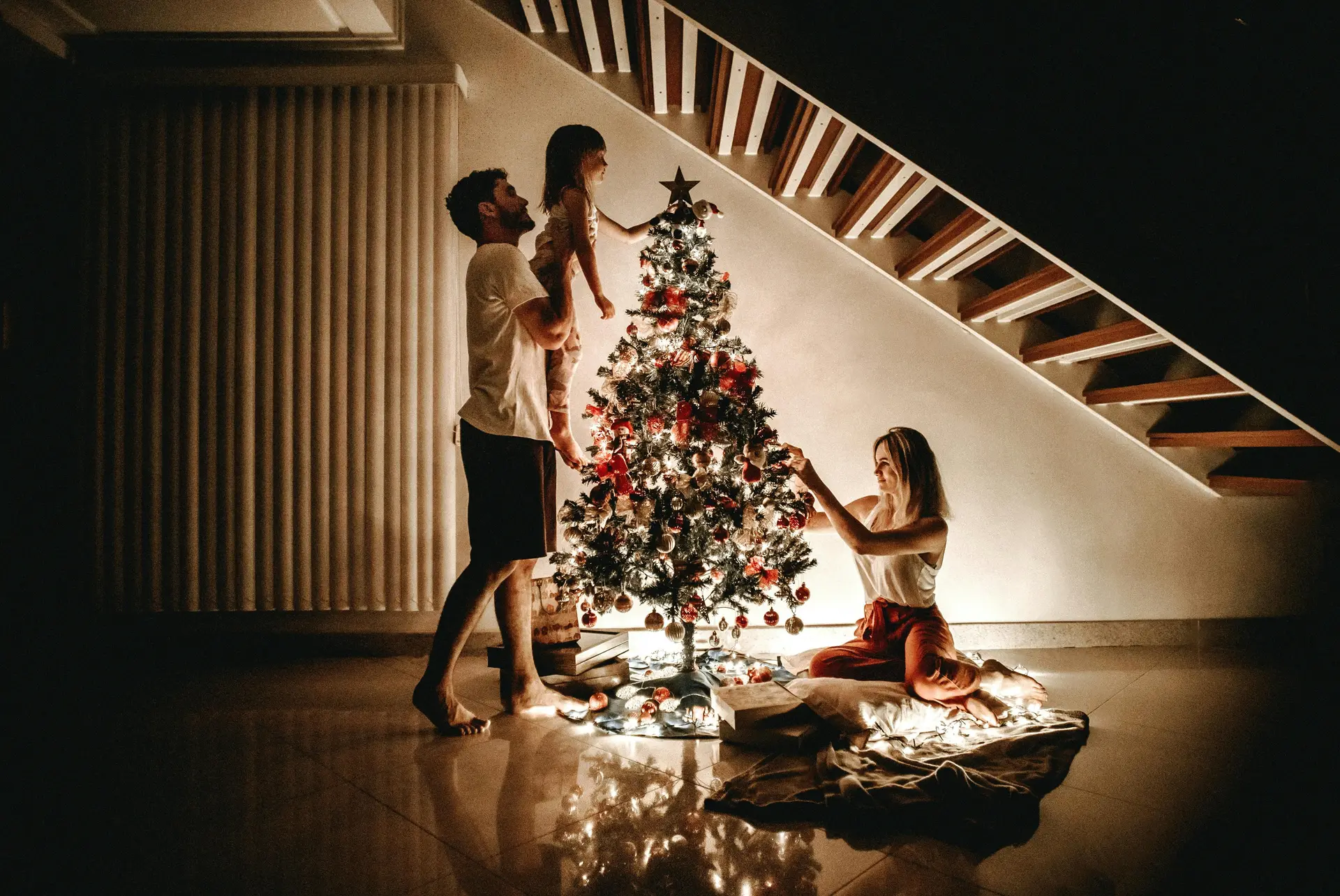 A family putting up ornamnets on the family christmas tree.