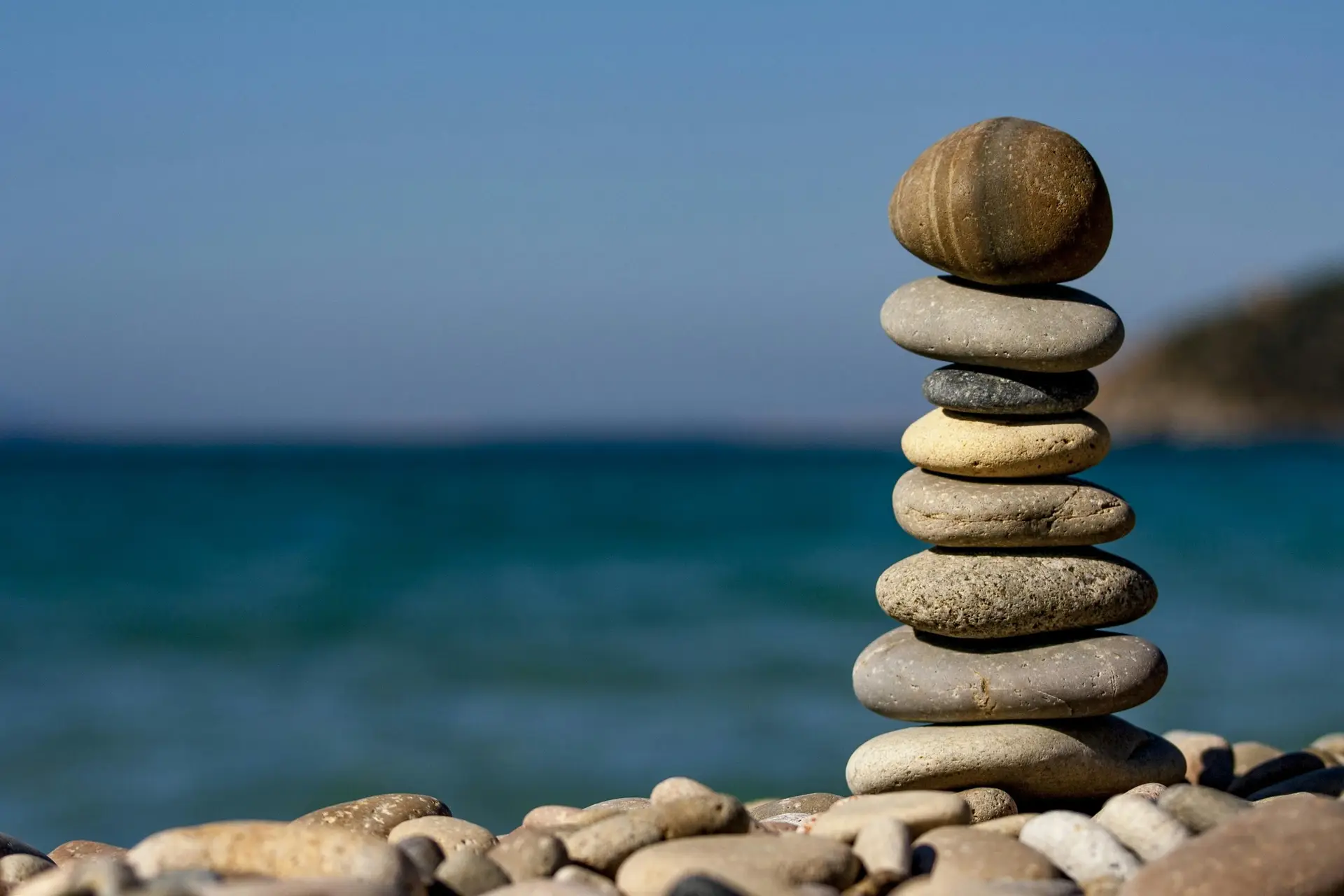 Pebbles piled up with ocean in the background.