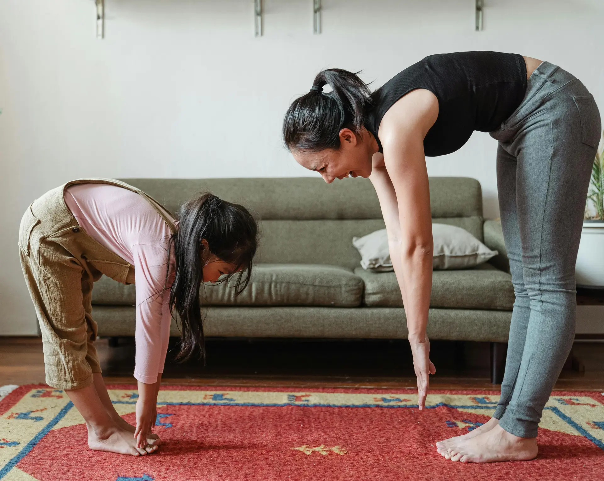A woman and a baby girl doing exercise at home.