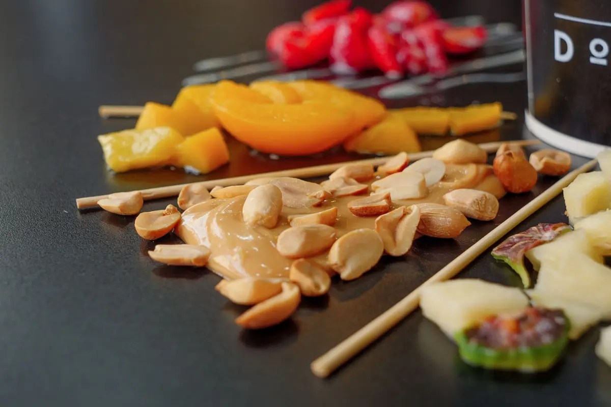 assorted fruits, nuts, and peanut butter on skewers, showcasing a vibrant, healthy snack