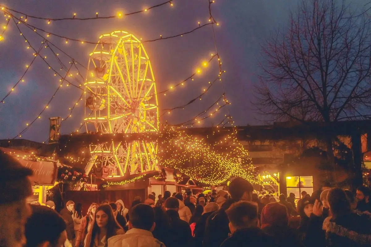 A crowd in a Christmas market, a perfect place to sing Christmas Carols.