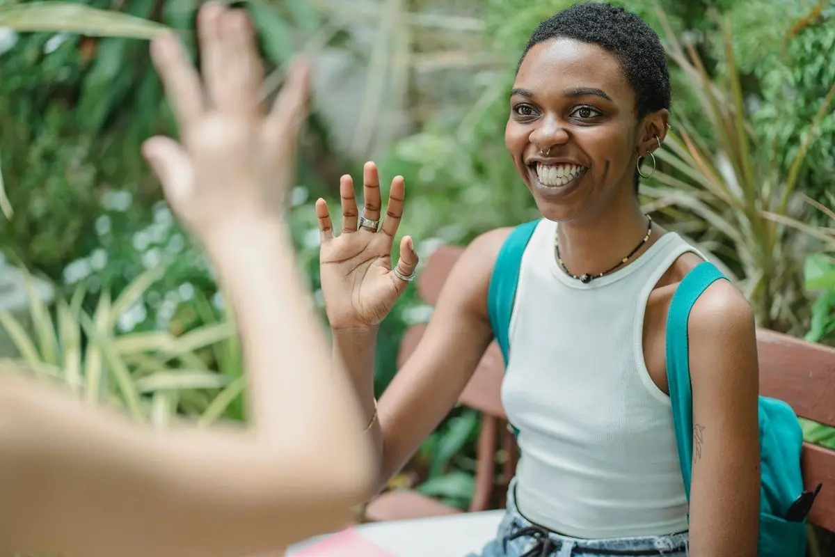 Two person waving at each other.