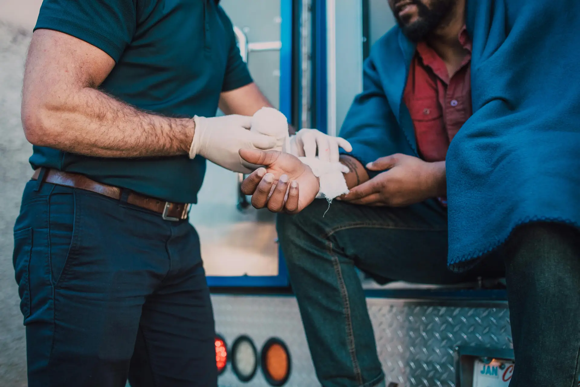 A doctor bandaging arm of an accident victim.