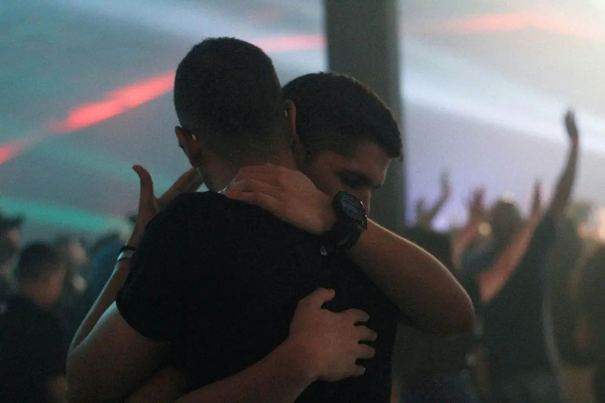 Two person hugging in a concert or nightclub.