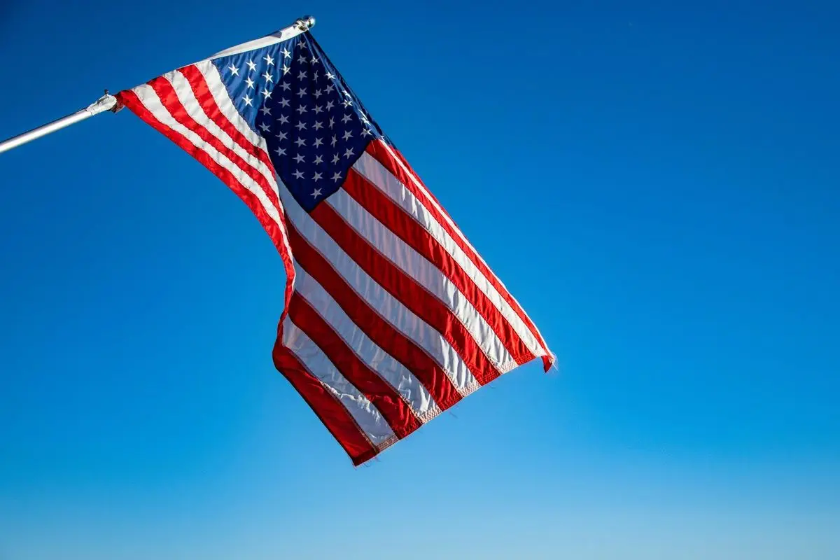 Flag of America waving in day time on a pole.