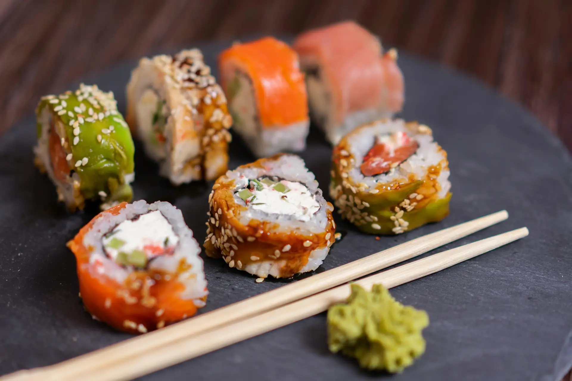 Sushri rolls on a plate with two chopsticks.