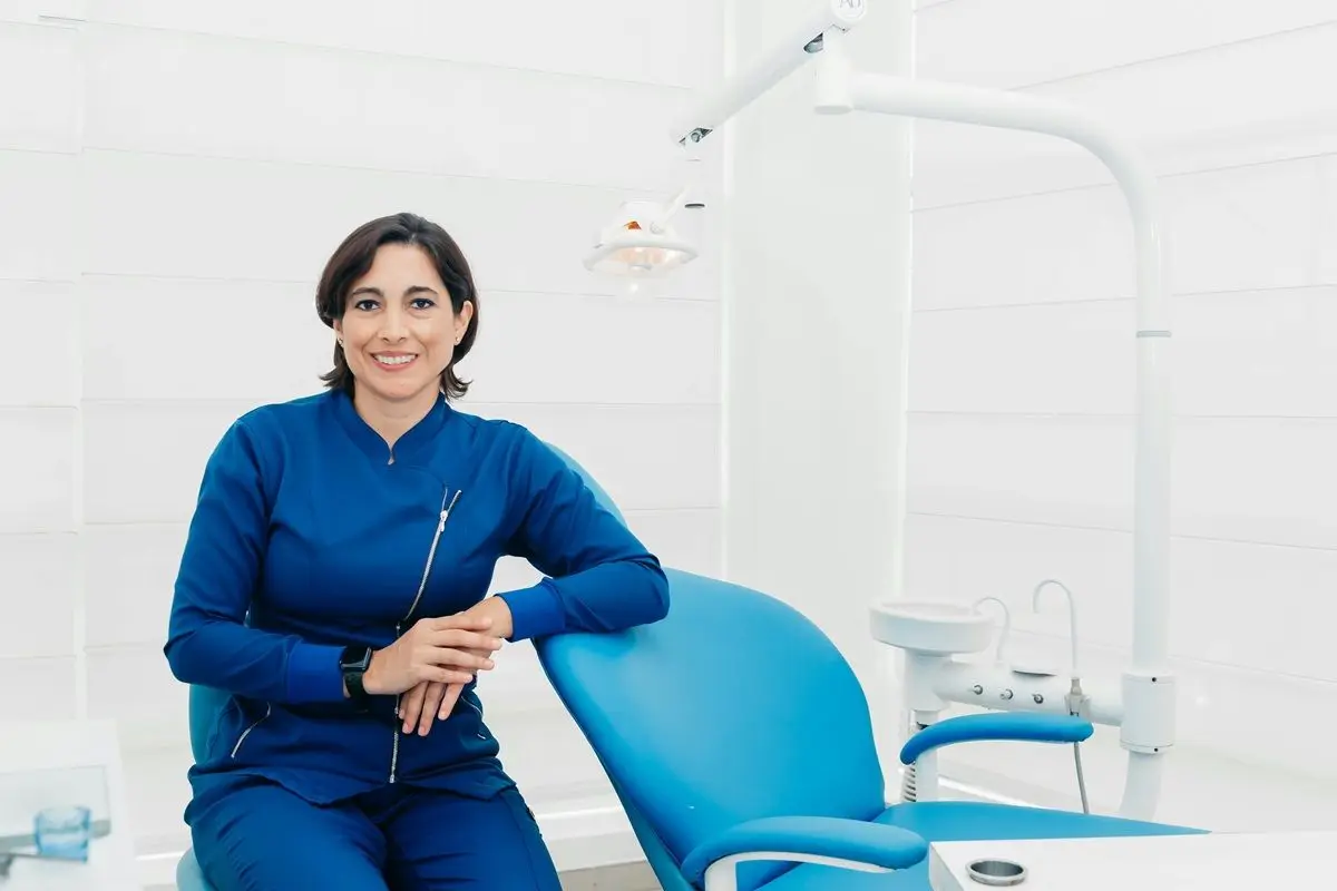 A dentist smiling in her dental chamber.