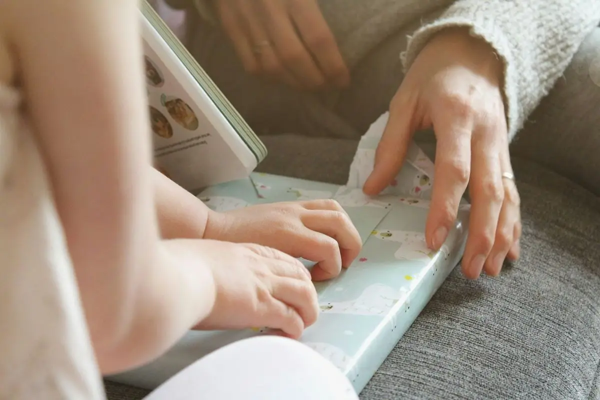 A child and an adult folding a gift together.