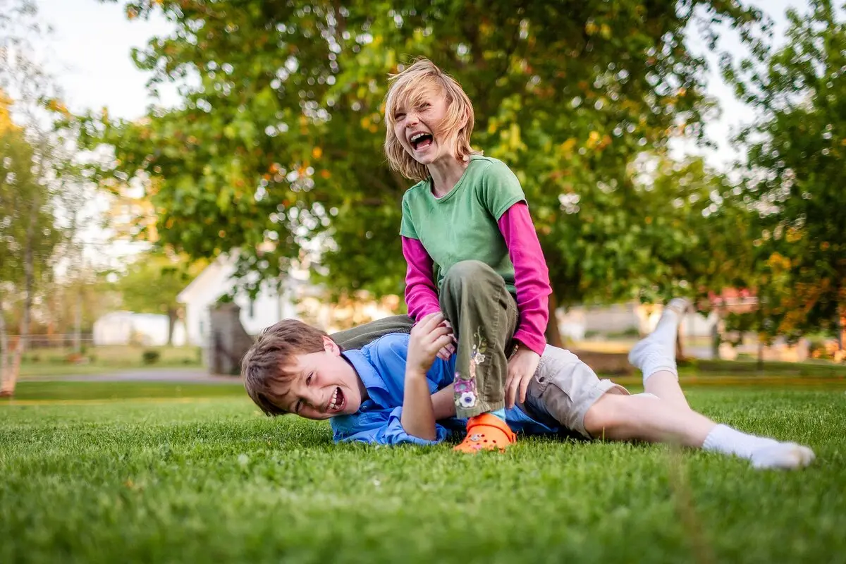 Laughter fills the air as two cousins enjoy a playful summer day outdoors.
