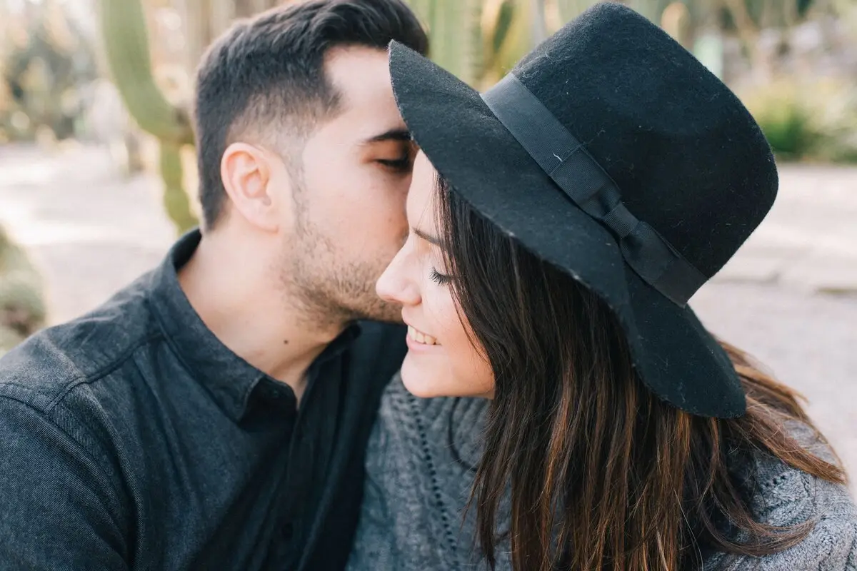A couple sharing a tender moment with a kiss outdoors, expressing affection and love.