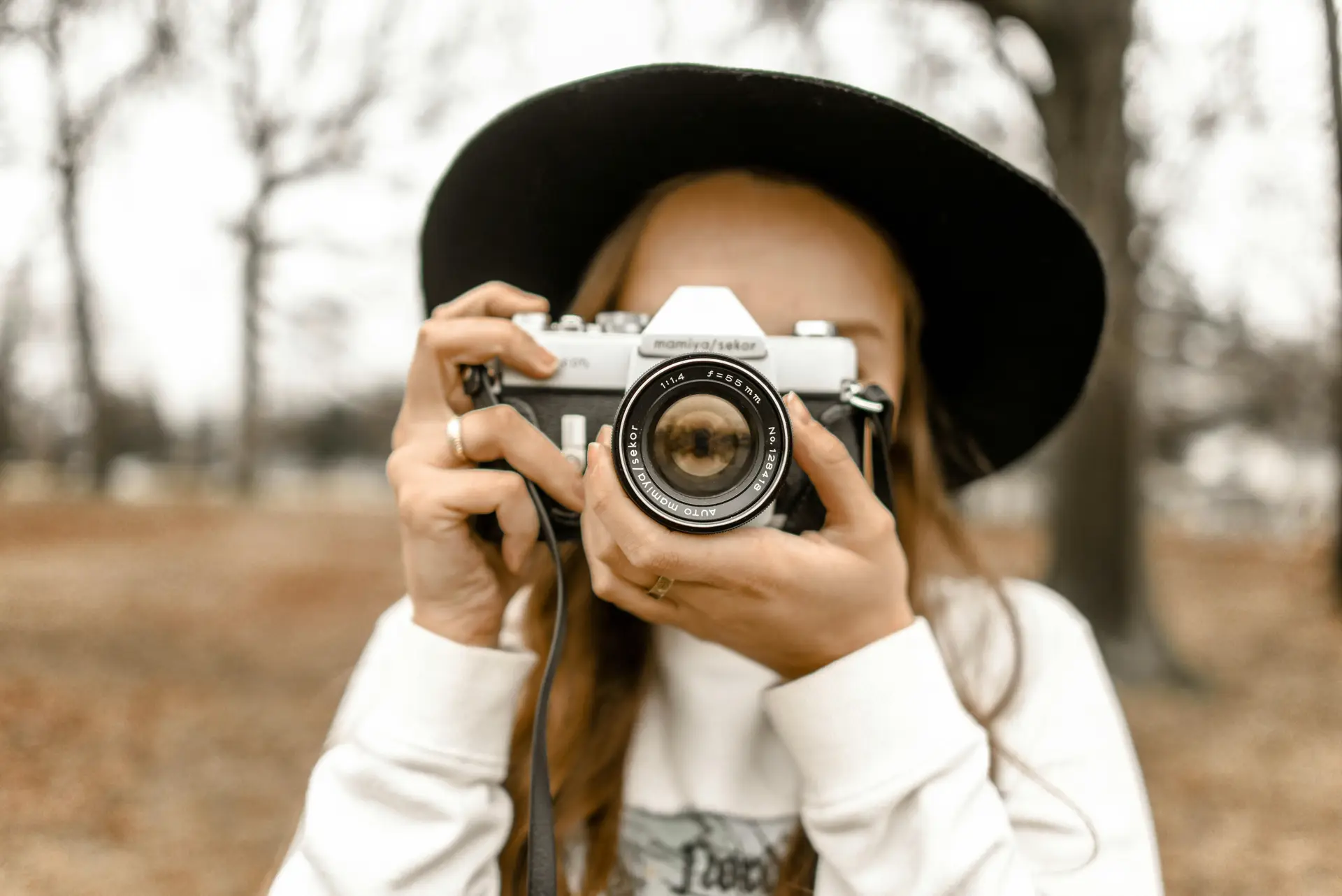 A woman is taking a picture with a camera.