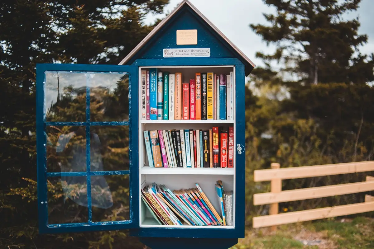 Outdoor little free library filled with books in a garden setting, promoting community literacy.