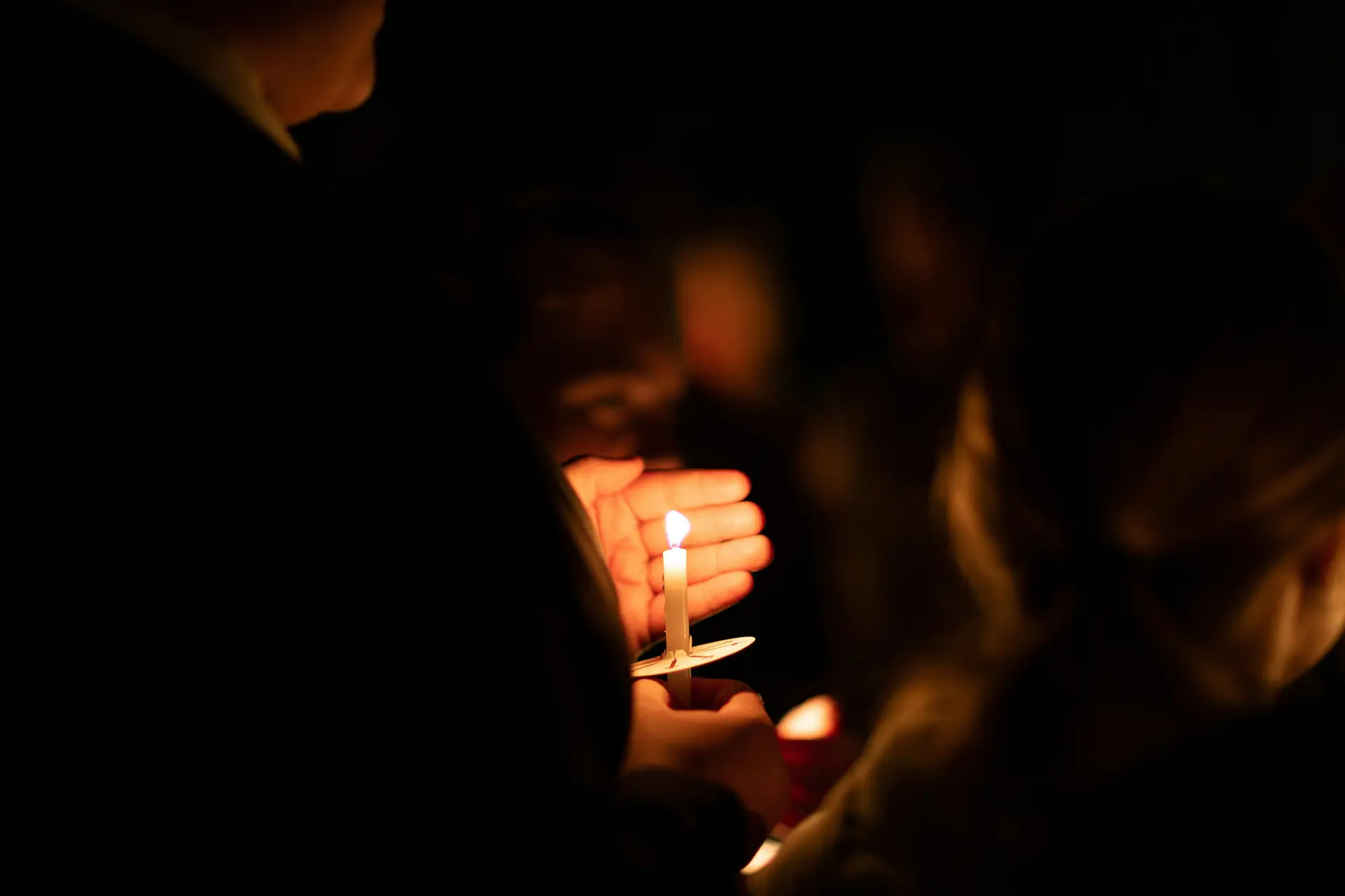 A person holding a candle in a vigil.