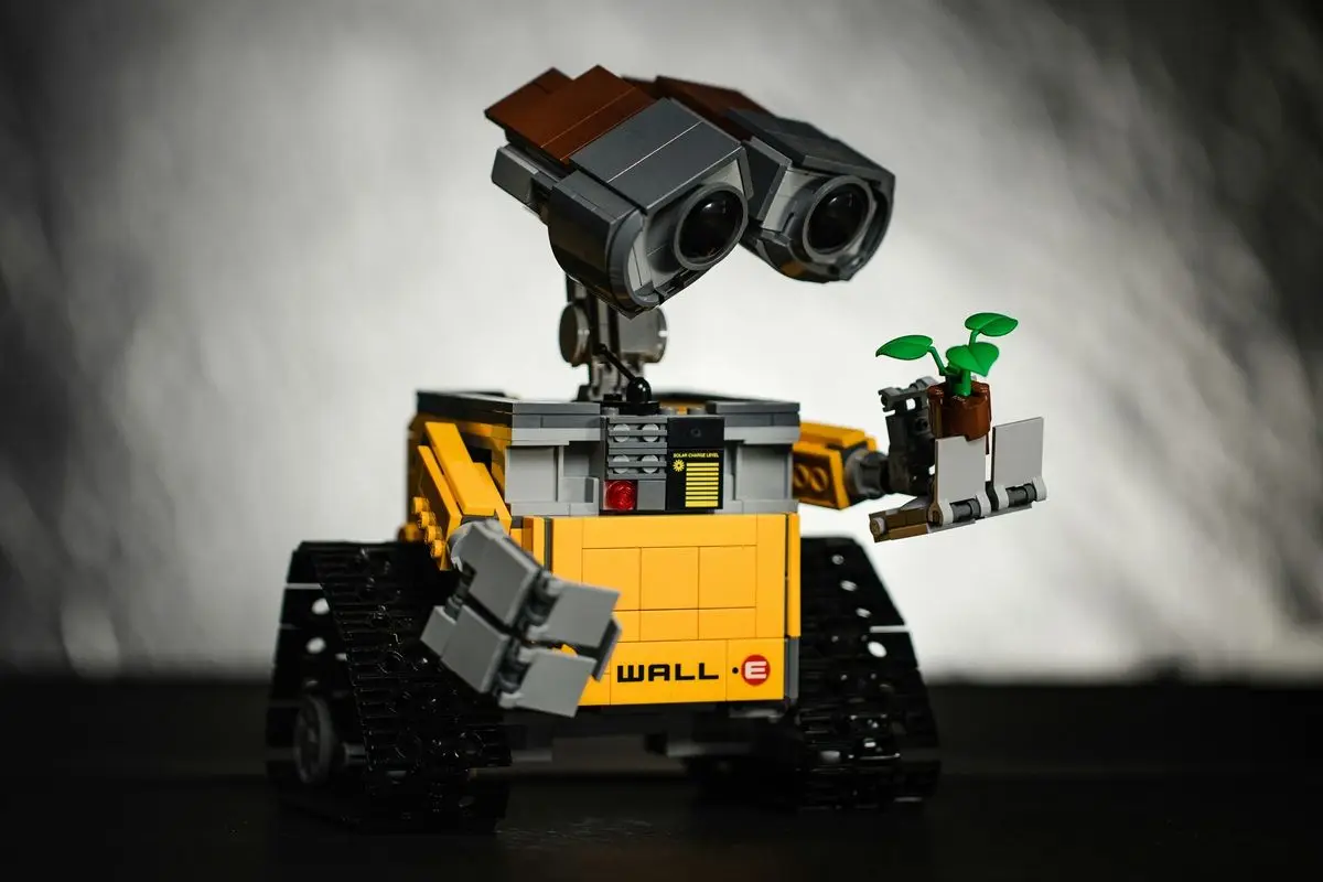 Life size replica of the Wall-E robot from the Wall-E movie, holding a plant.